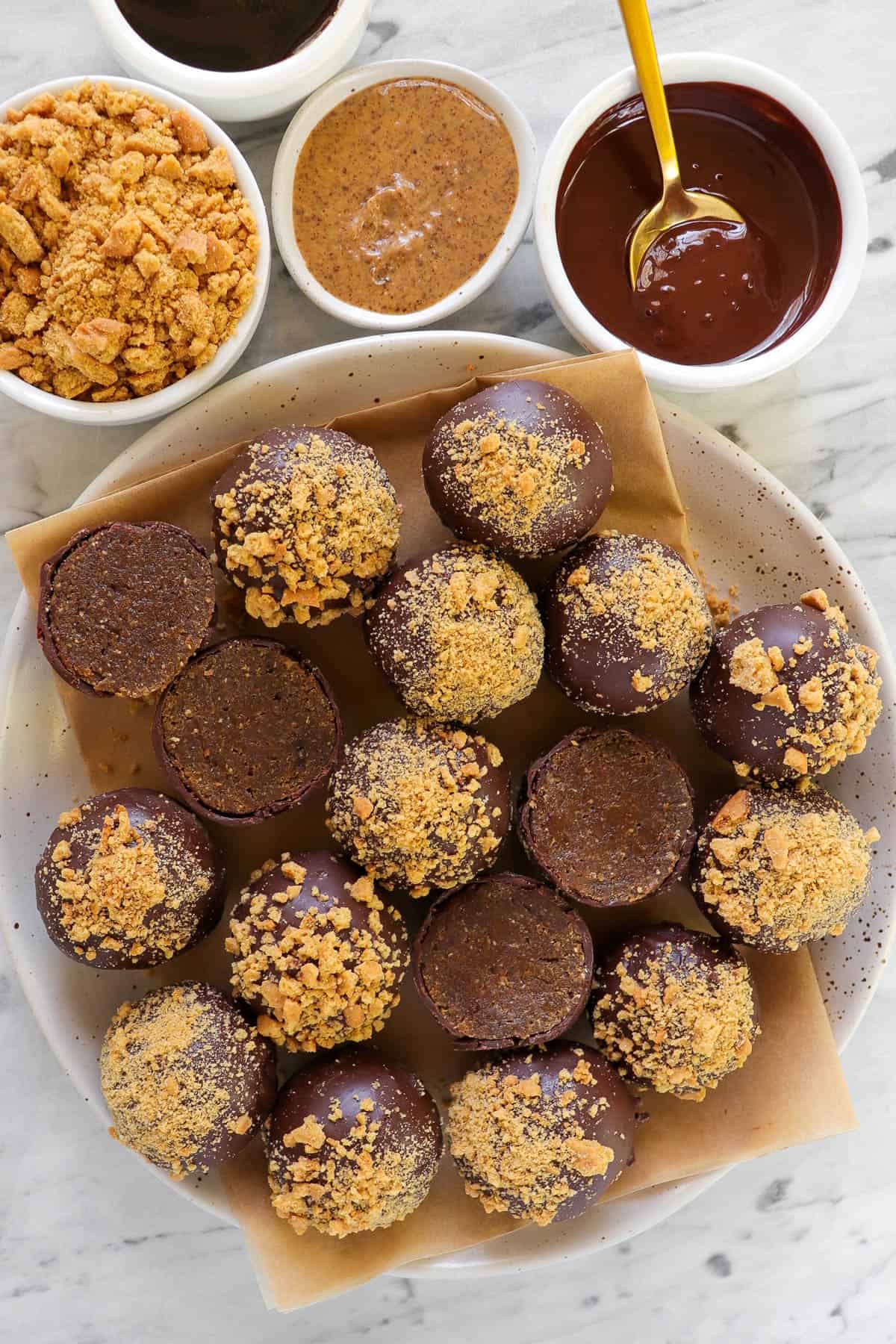 Truffles on plate with gingersnap biscuits, almond butter and melted chocolate on the side.