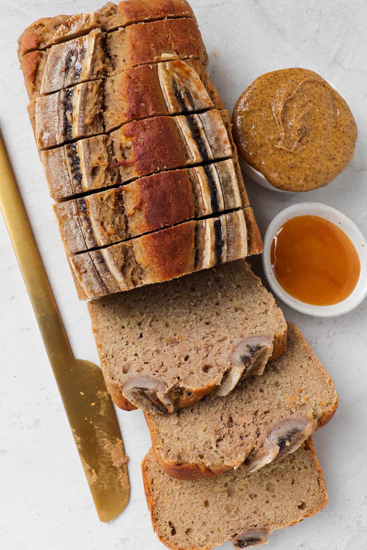 Sliced bread with honey and almond butter in mini dishes on the side.