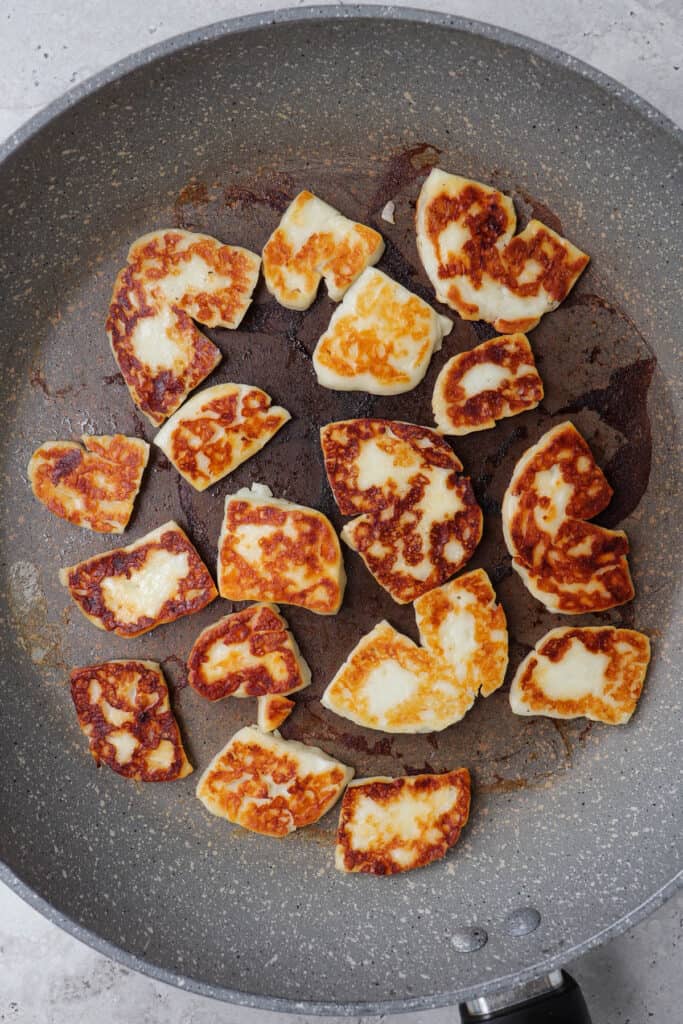 Fried halloumi in fry pan.