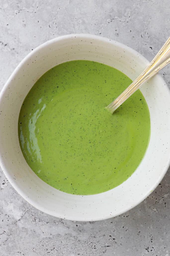 Green herb tahini sauce in a bowl.