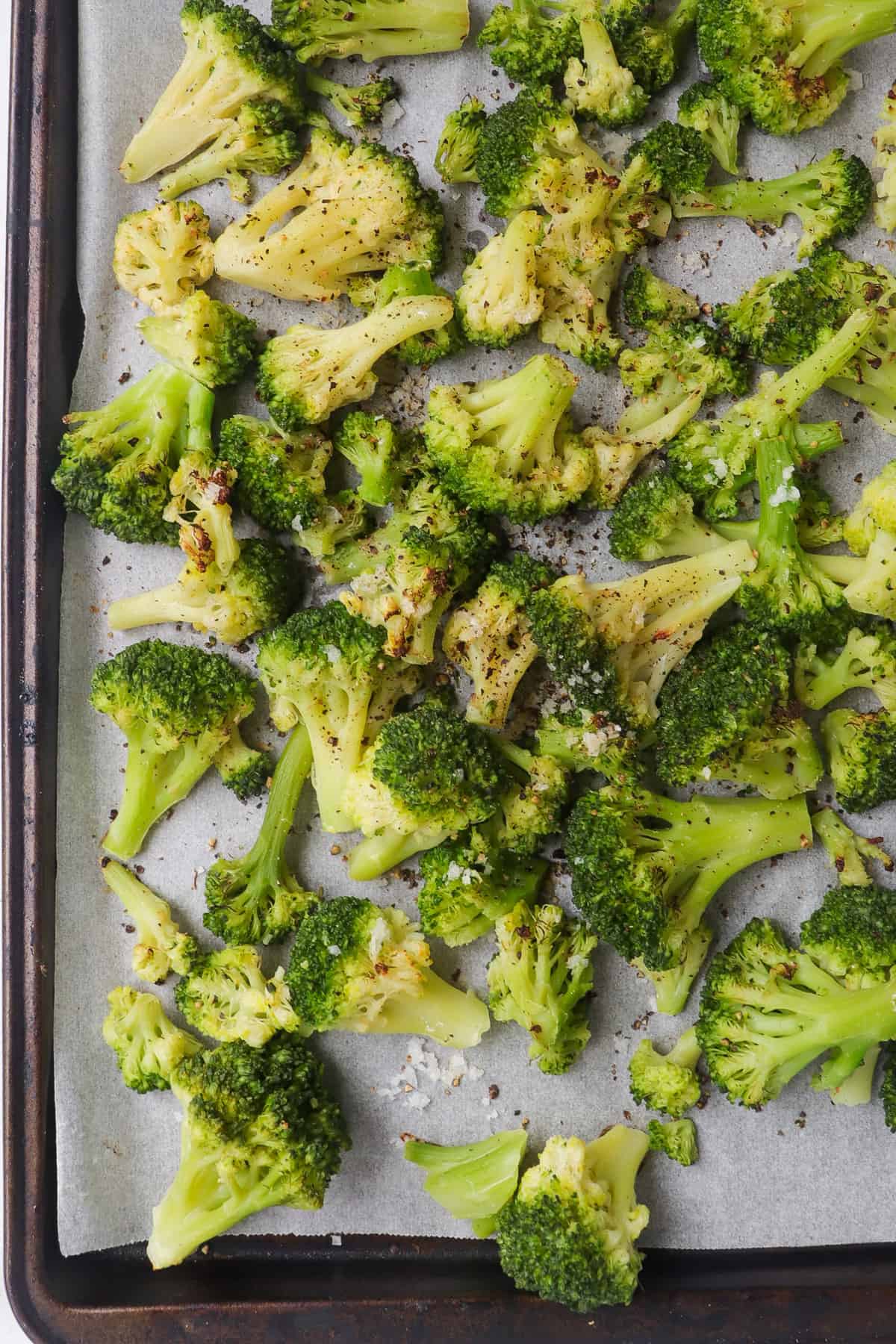 Roasted broccoli florets on baking sheet.