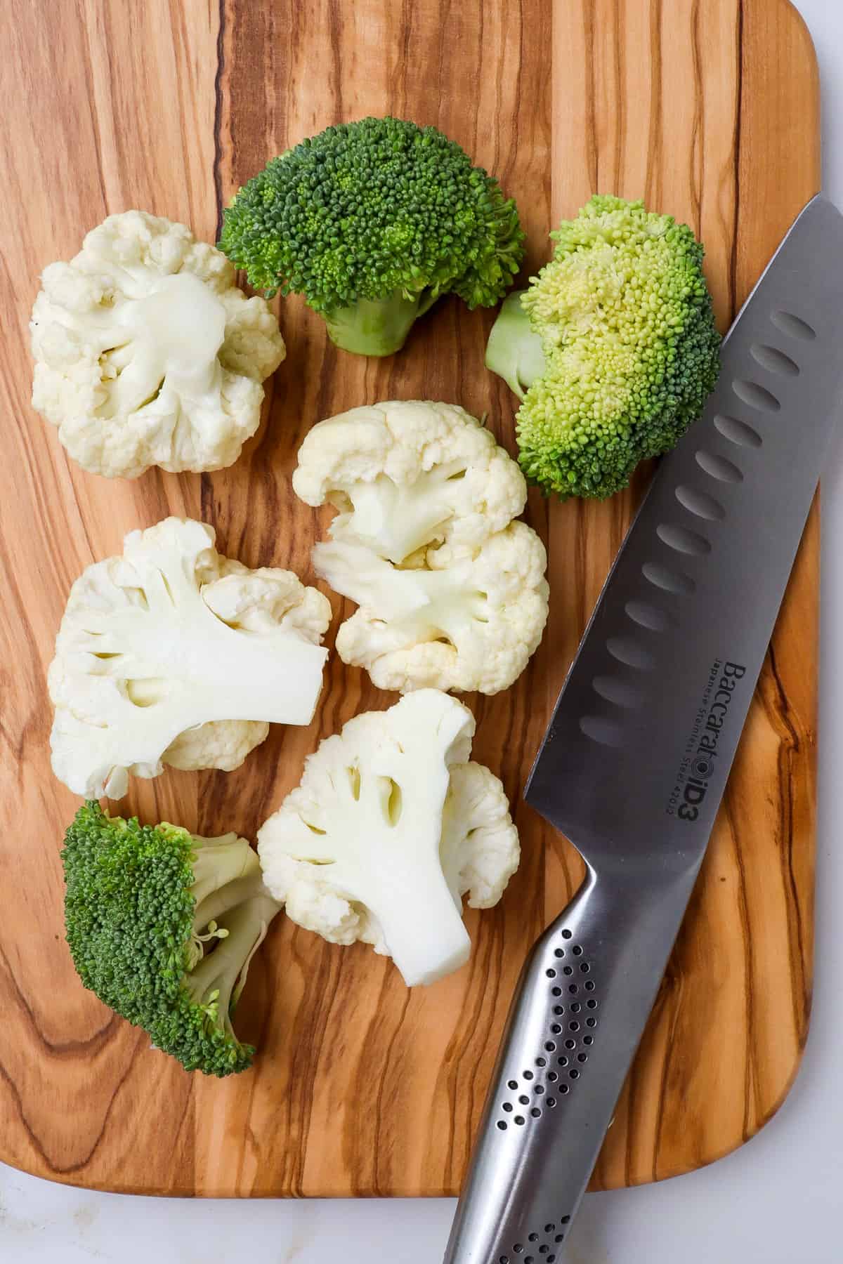 Broccoli and cauliflower florets on a chopping board.