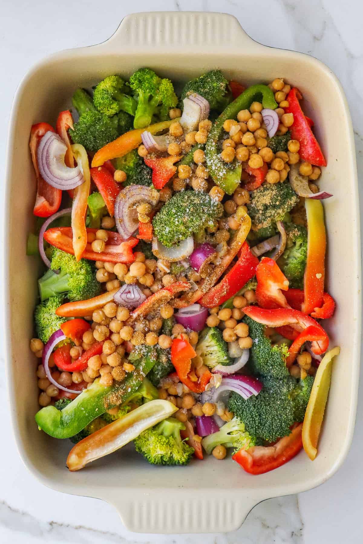 Unbaked chickpeas and veggies in dish before oven.