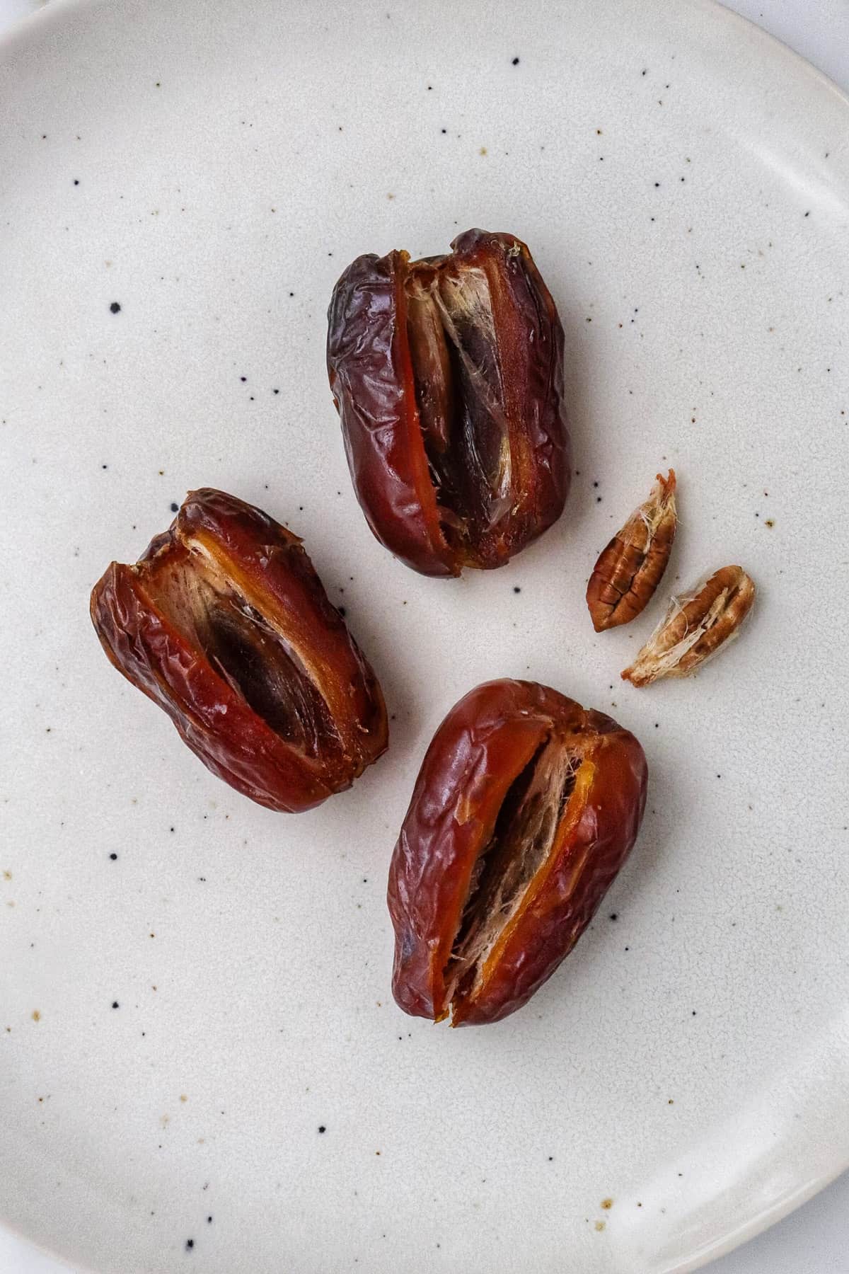 Three pitted dates on a plate.