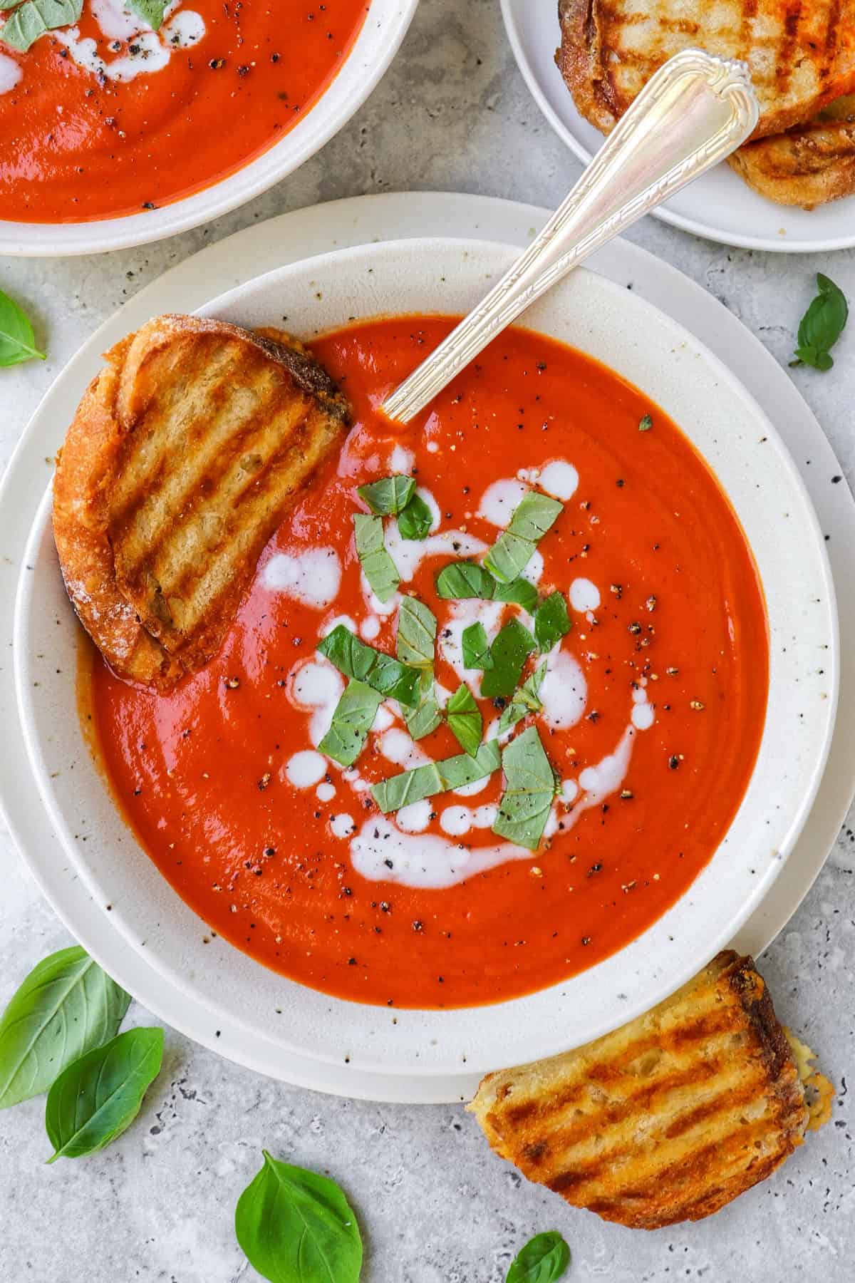 Tomato soup in a bowl with grilled cheese toast dunked in.