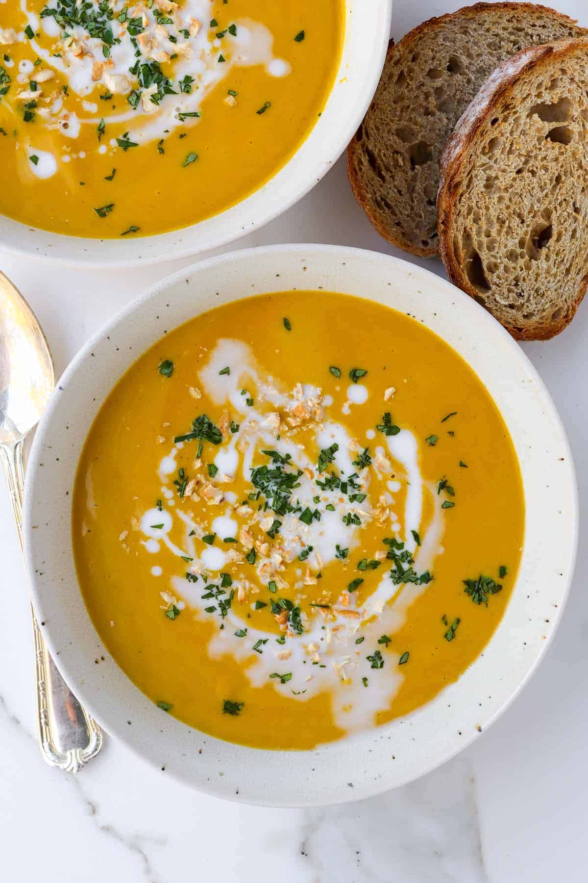 Soup in two bowls with toasted sourdough on the side.