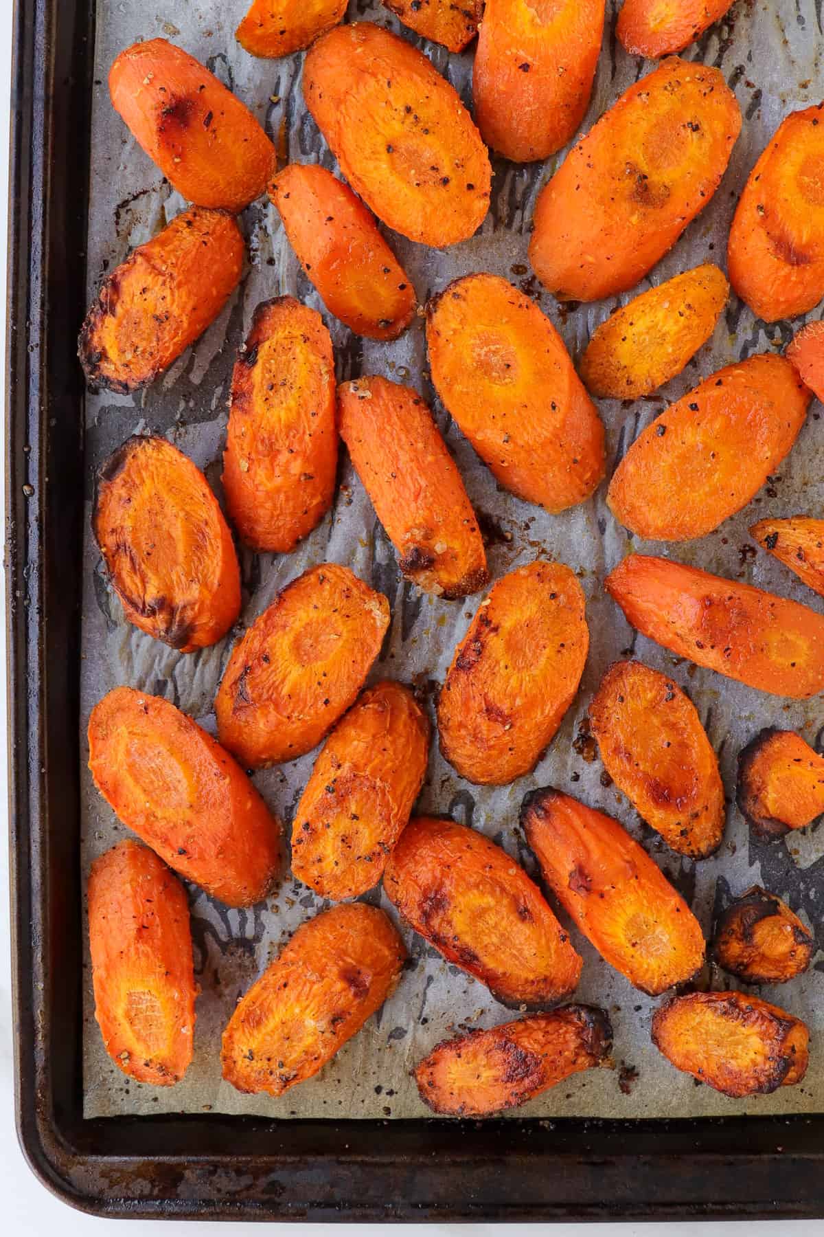 Roasted carrot slices on baking tray.