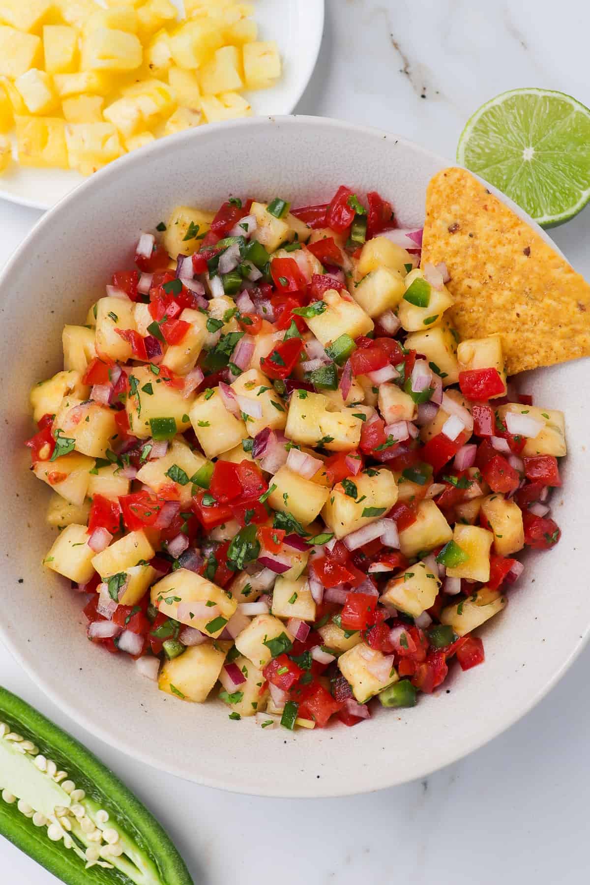 Pineapple salsa in a bowl with a corn chip.