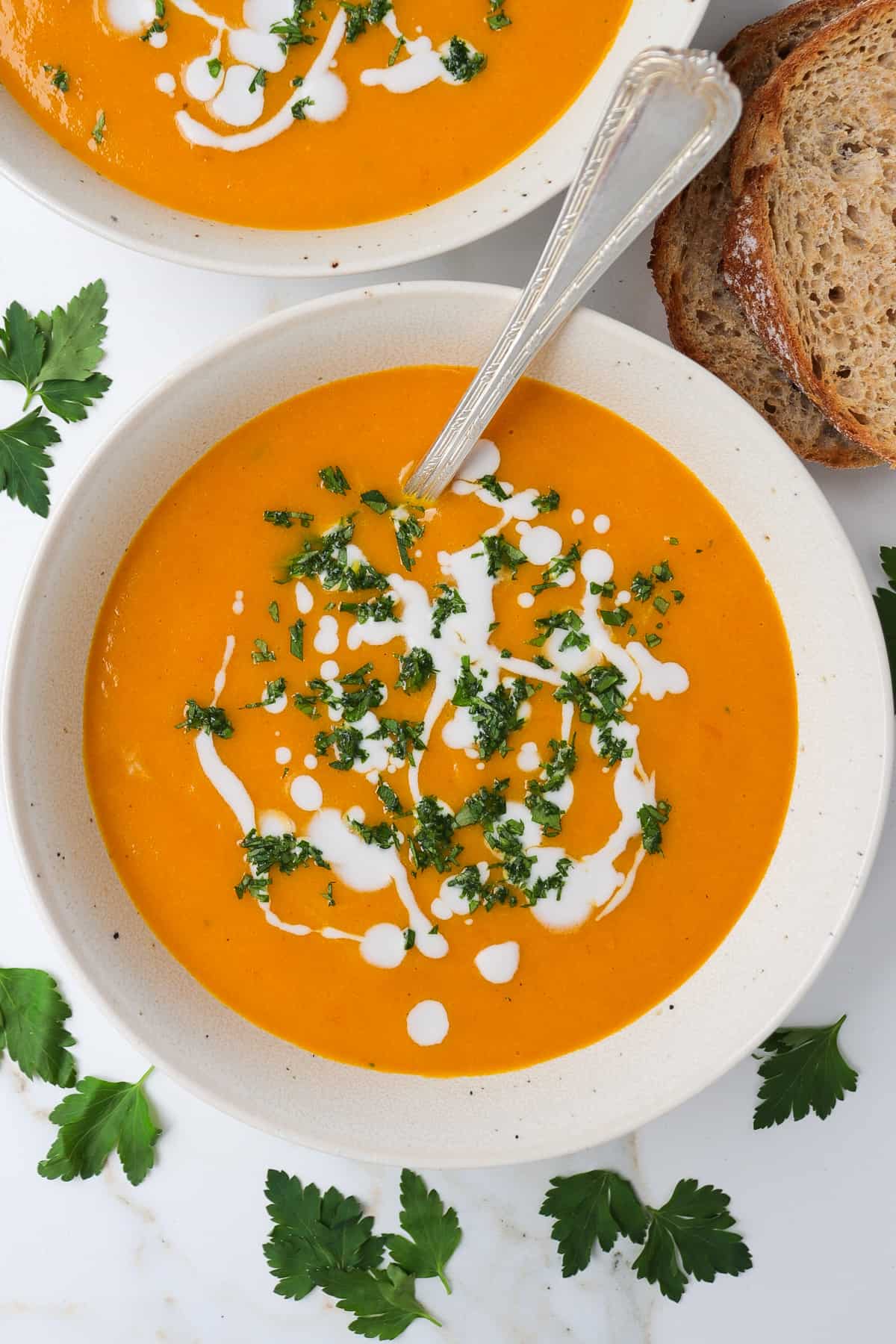 Pumpkin soup in bowl with spoon.