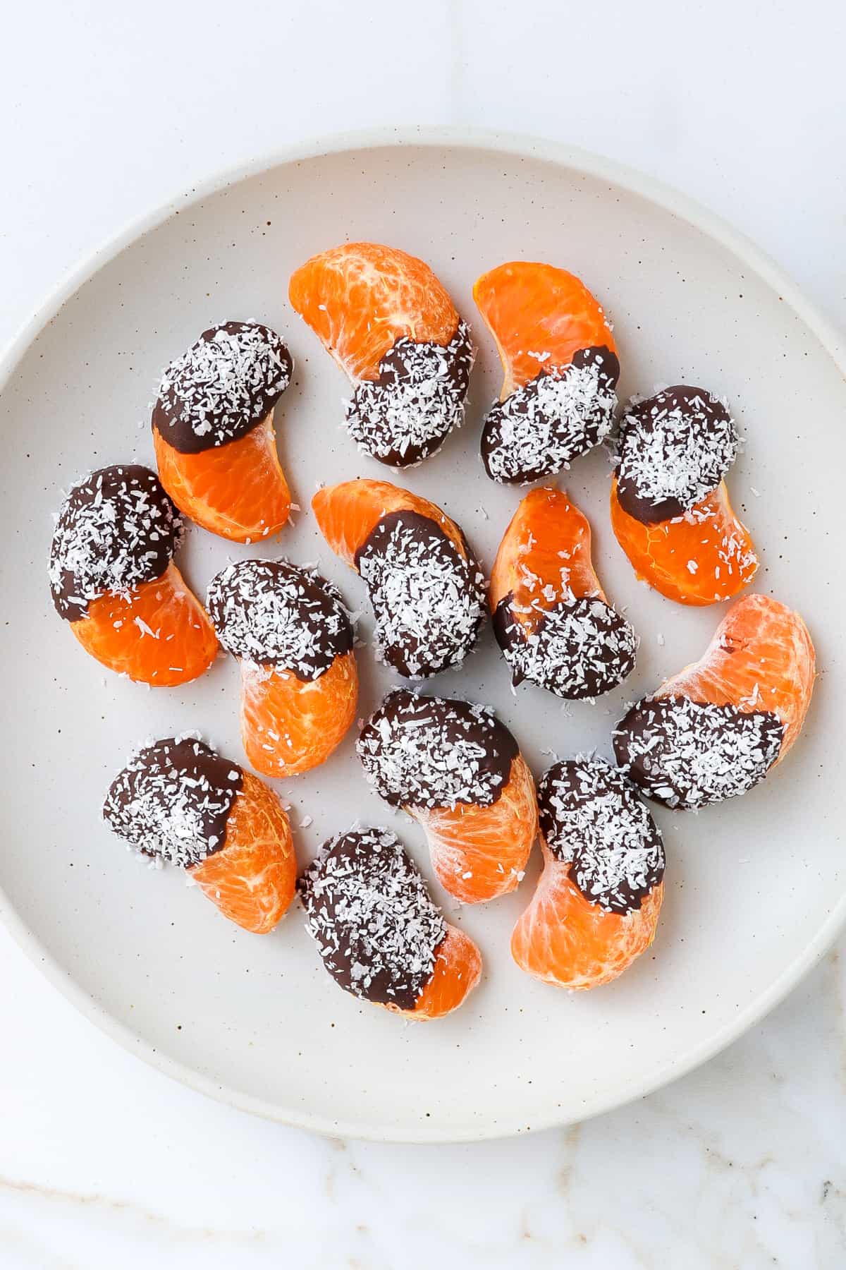 Chocolate covered orange pieces sprinkled with coconut.