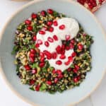 The Cypriot grain salad in a bowl with yoghurt and pomegranate seeds on top.
