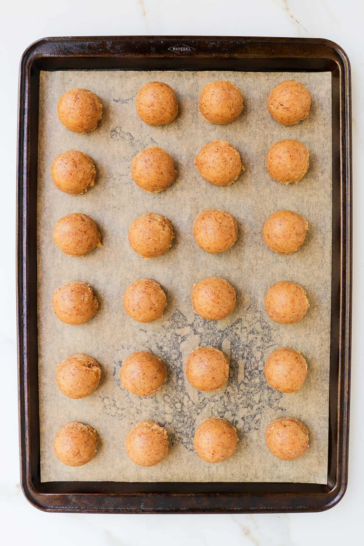Cookie dough balls on baking tray.