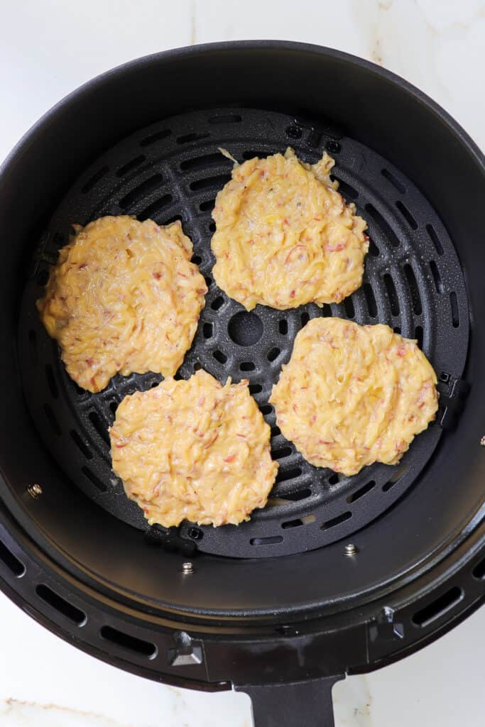 Potato pancakes mixture in air fryer before cooked.