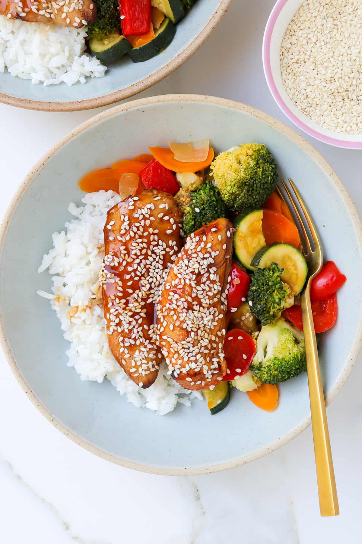 Teriyaki chicken in a bowl with veggies and rice.