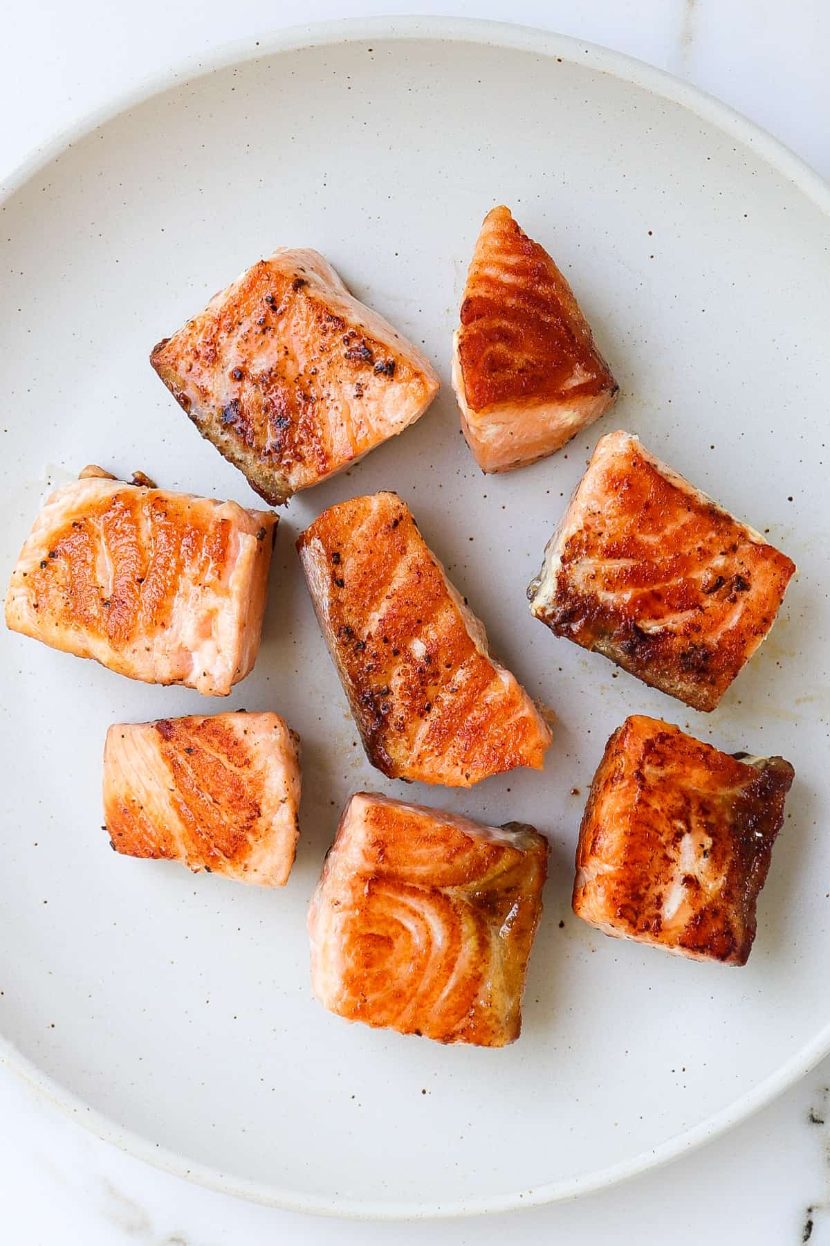 Grilled salmon chunks on a plate.