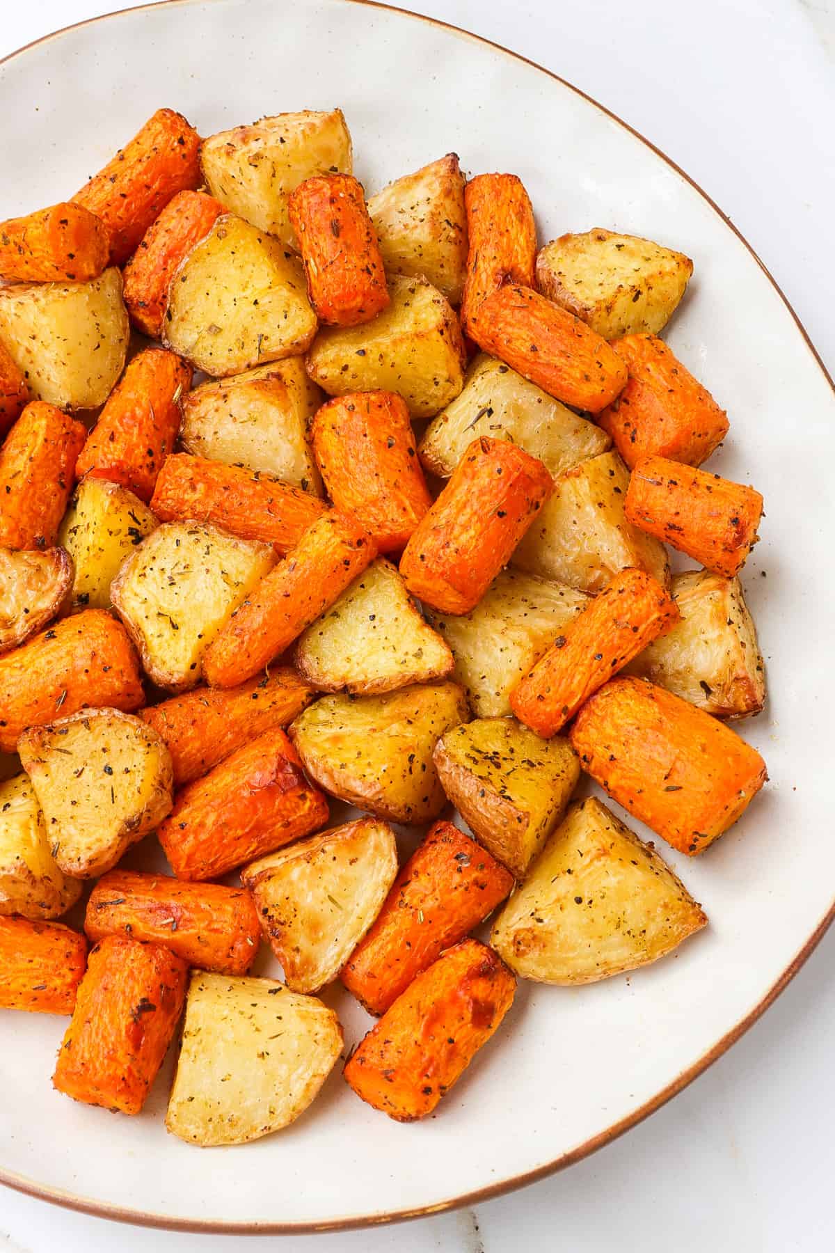 Close up shot of roasted carrots and potatoes.
