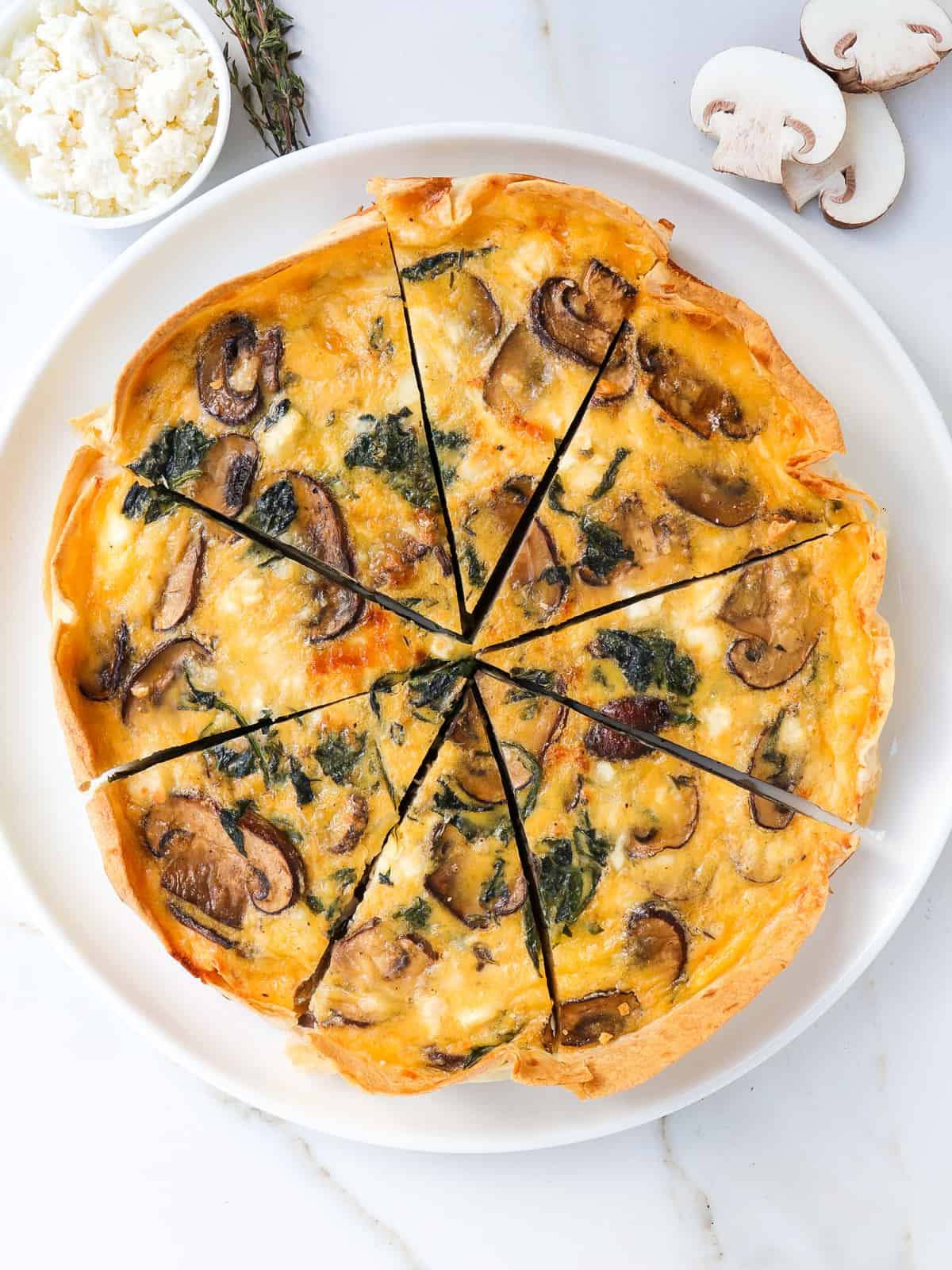 Spinach mushroom quiche on a plate.