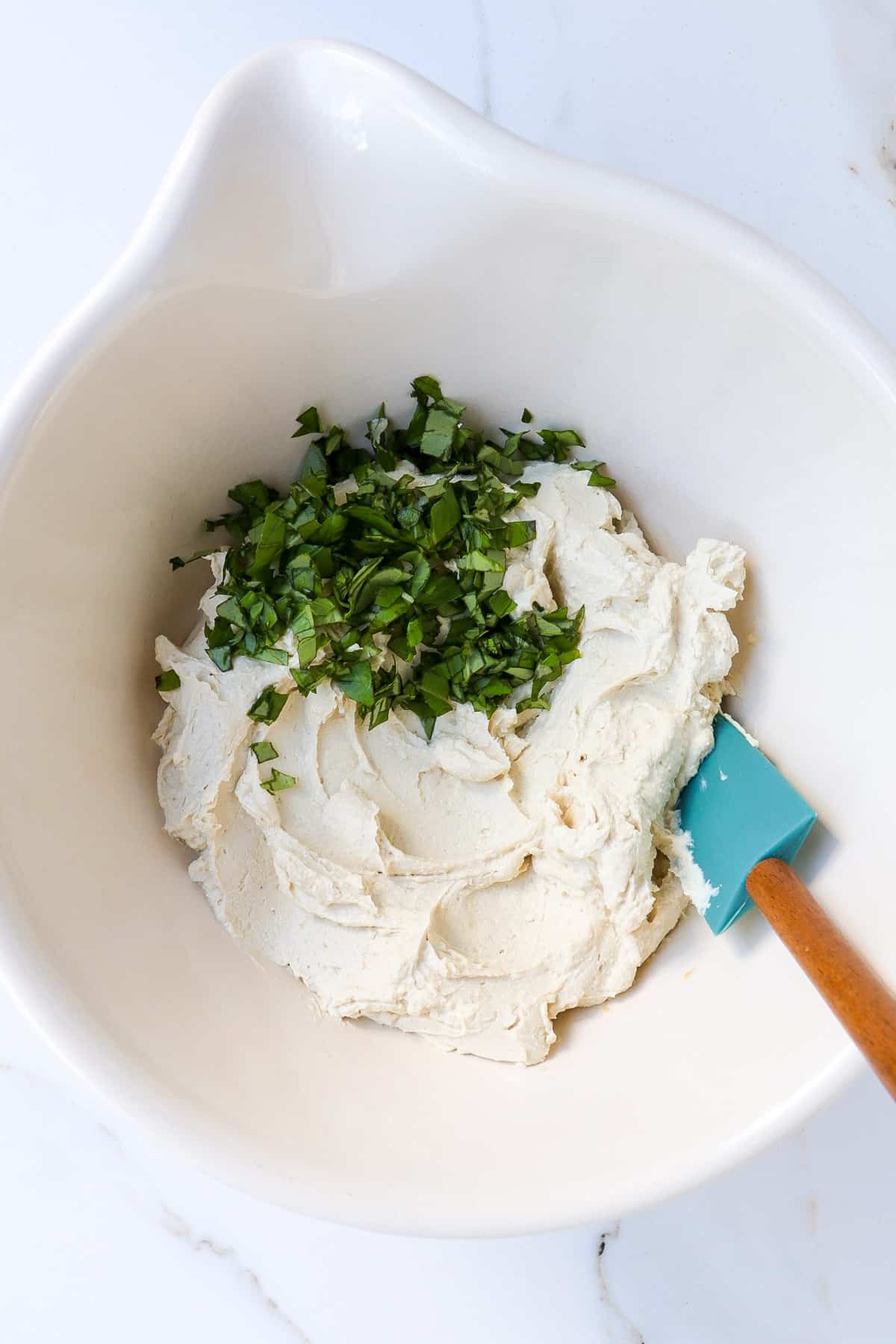 Tofu ricotta in a bowl with basil.
