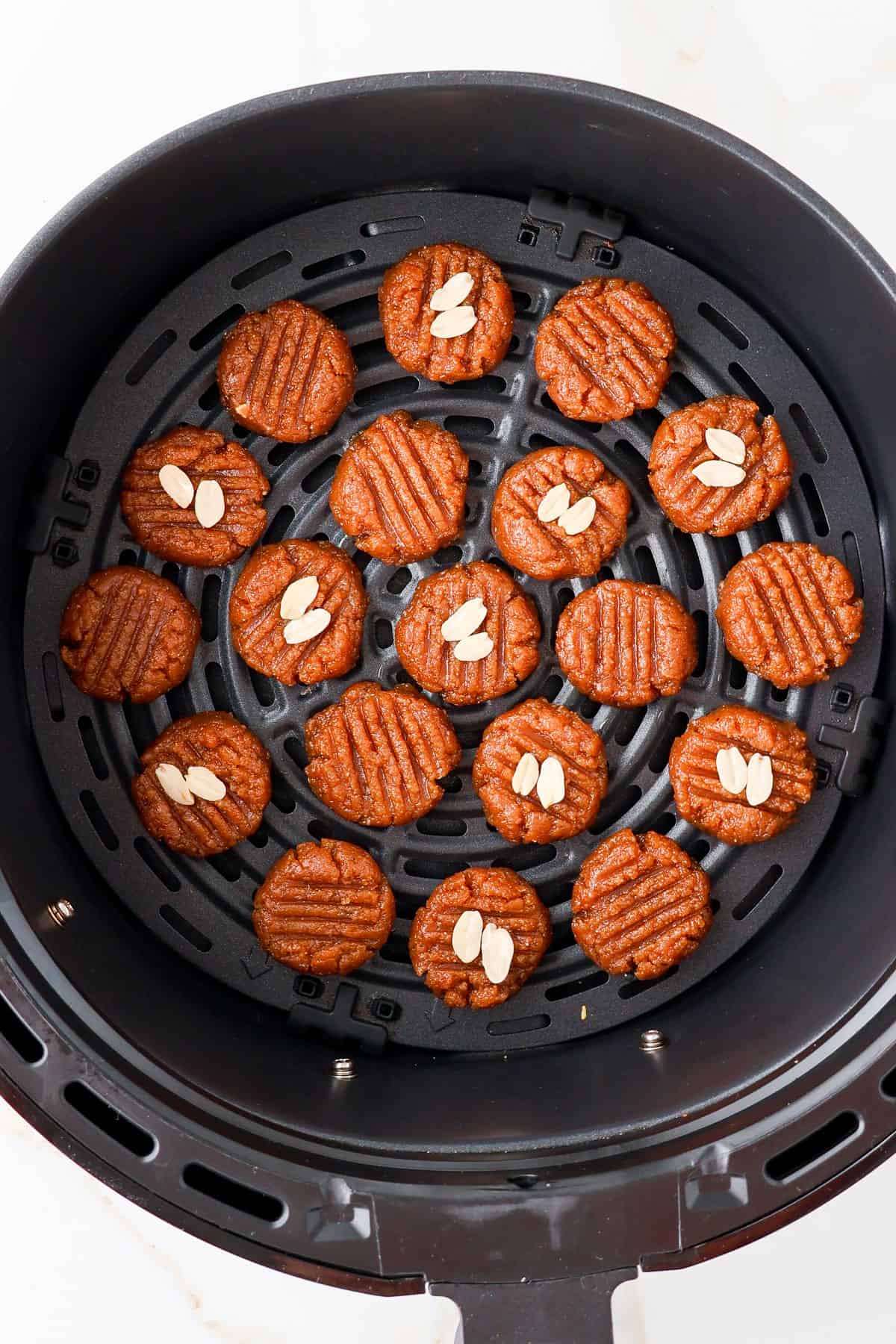 Raw cookies in air fryer basket.