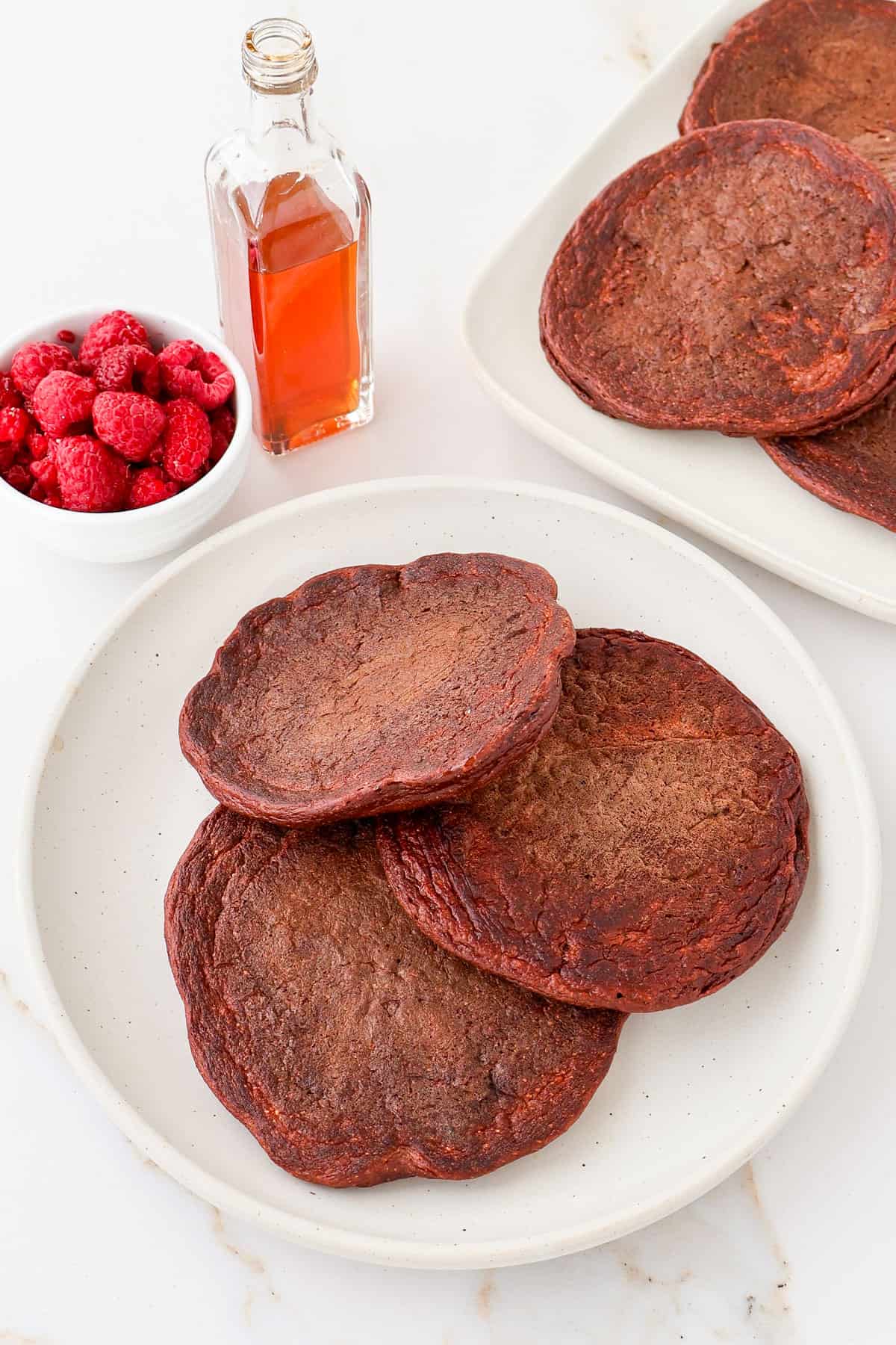 Chocolate pancakes on a plate and platter.