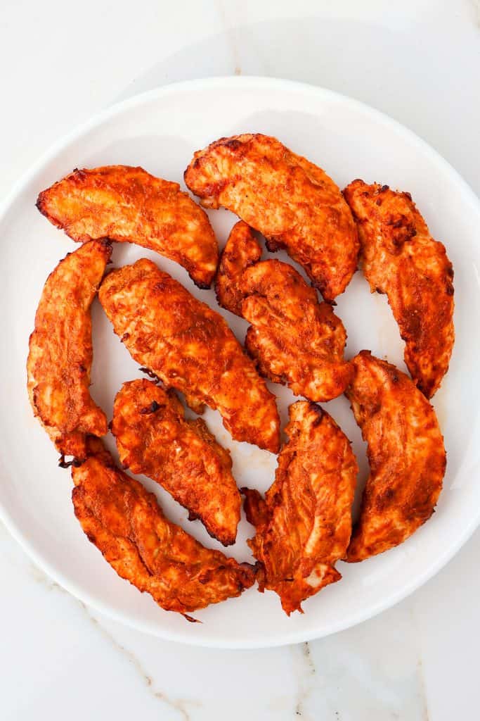 Cooked chicken tikka pieces on a plate.