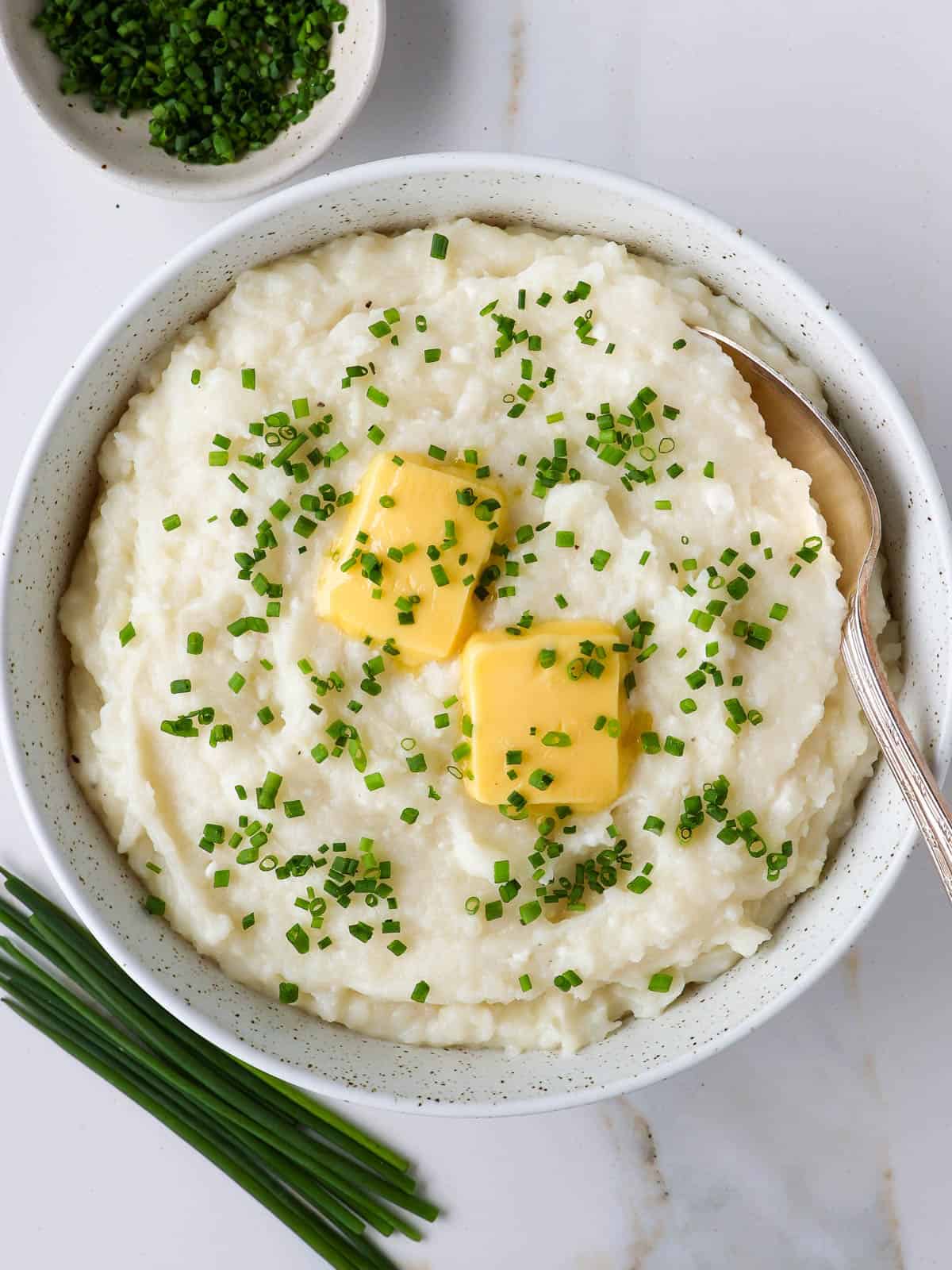 Mashed potatoes in a bowl with a spoon.