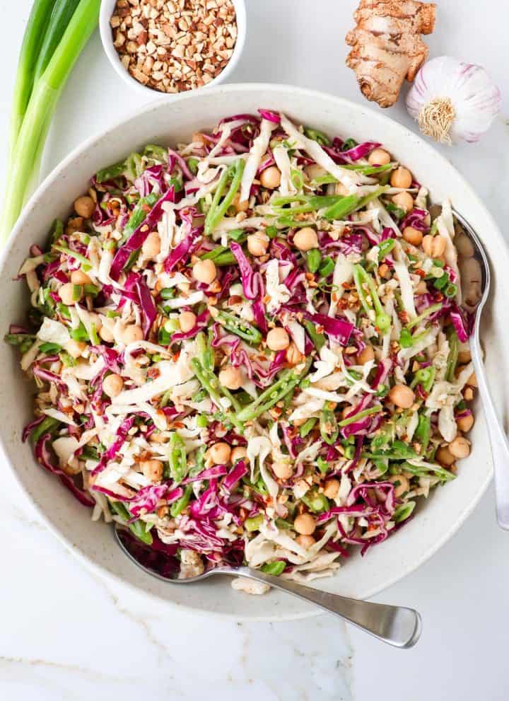 Chickpea cabbage salad in a bowl with spoons.