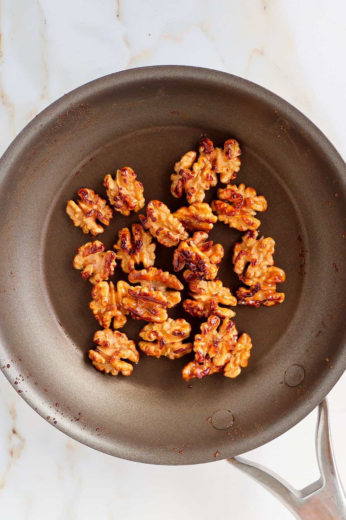 Candied walnuts in a skillet.