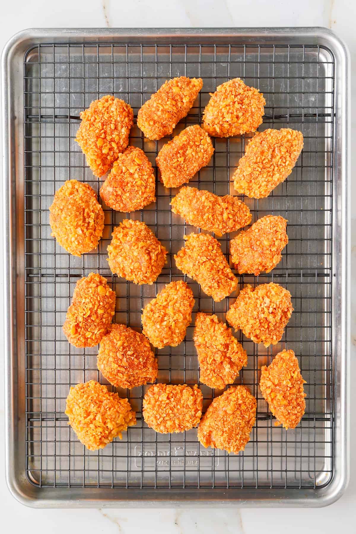 Crumbed chicken on a wire rack.