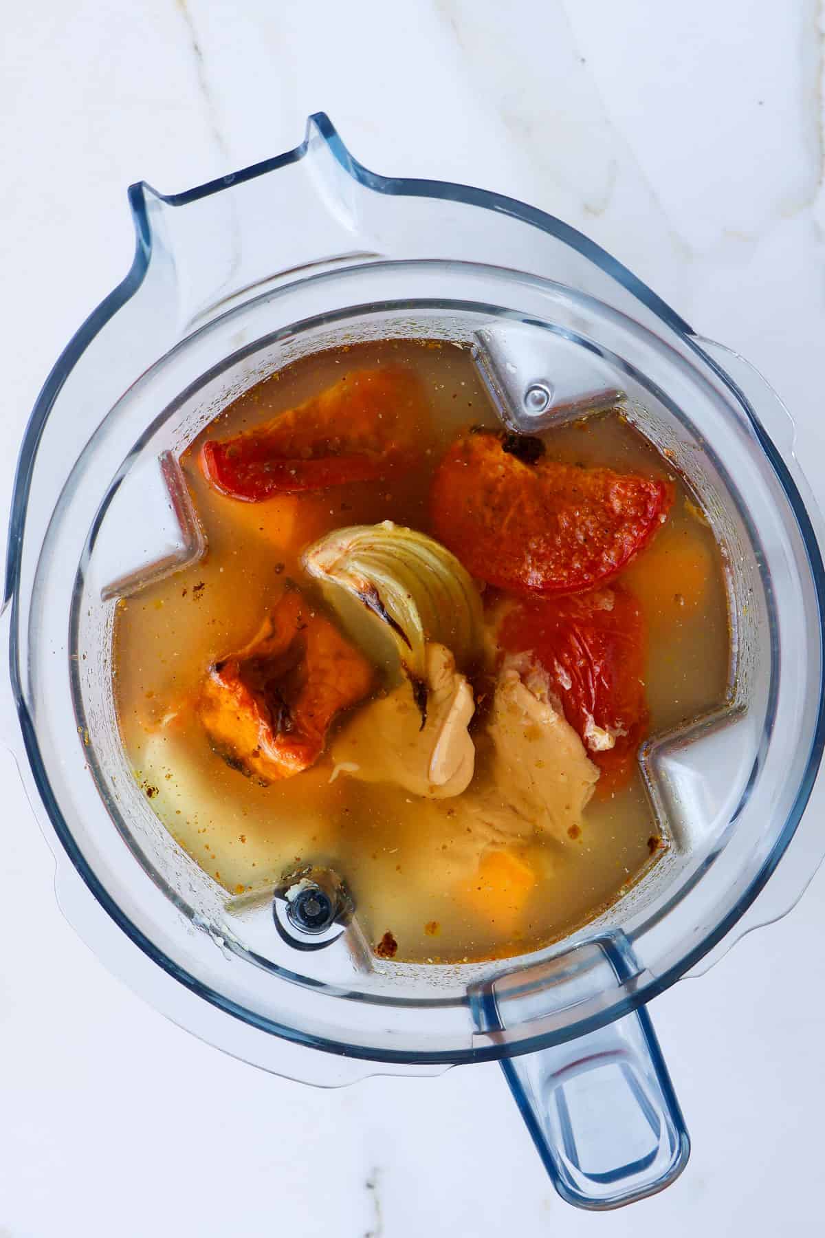 Roasted vegetables in a blender with stock and peanut butter.