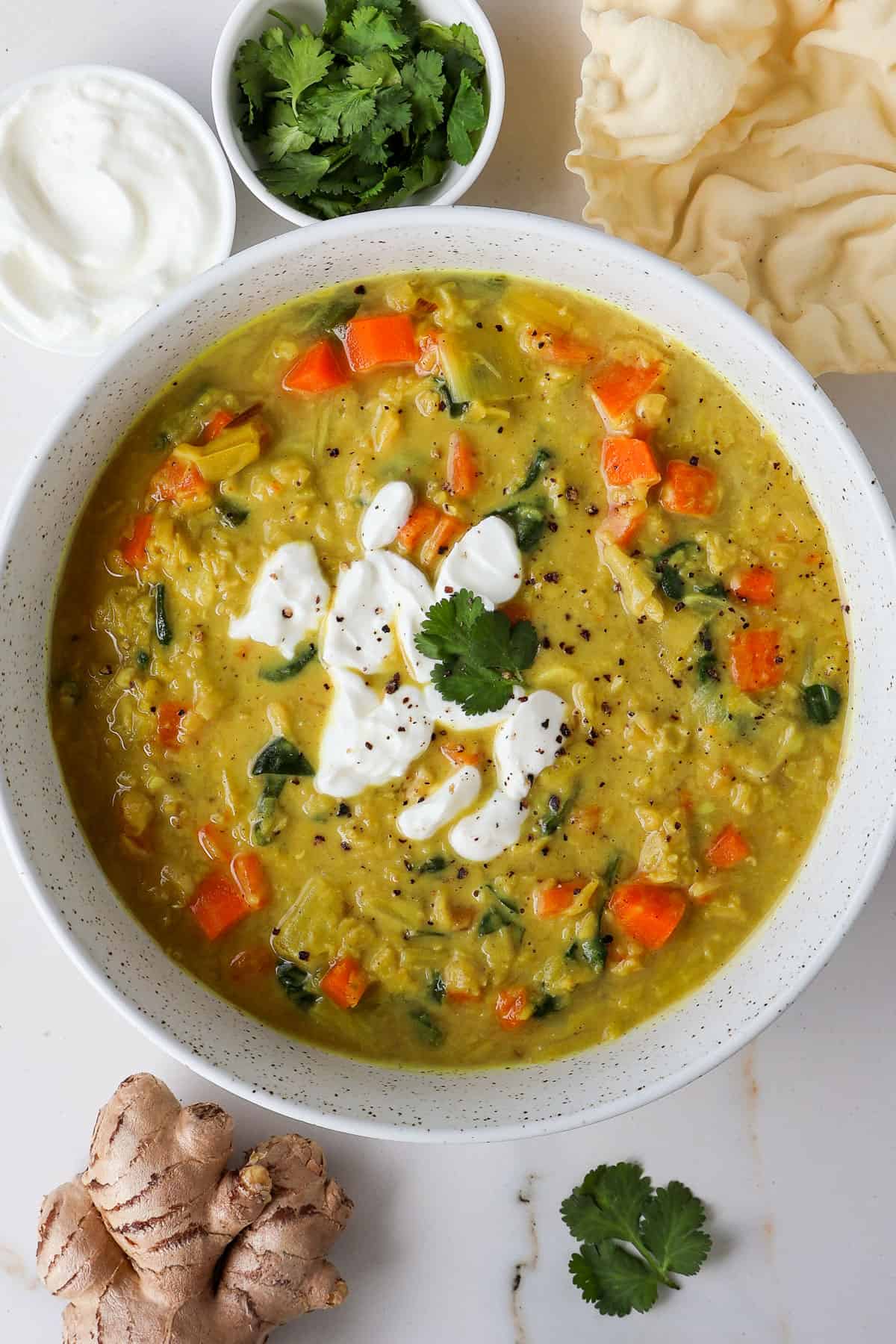 Carrot soup in a bowl topped with yoghurt and coriander.