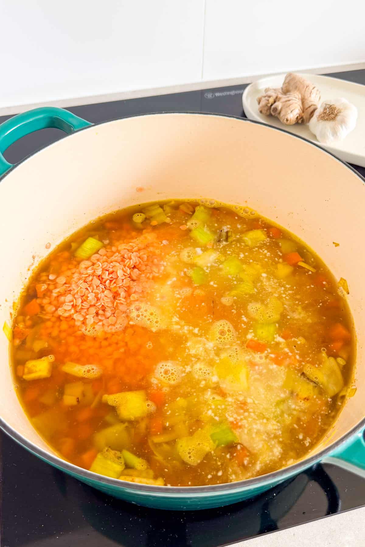 Dried lentils, coconut milk and broth added to the pot.
