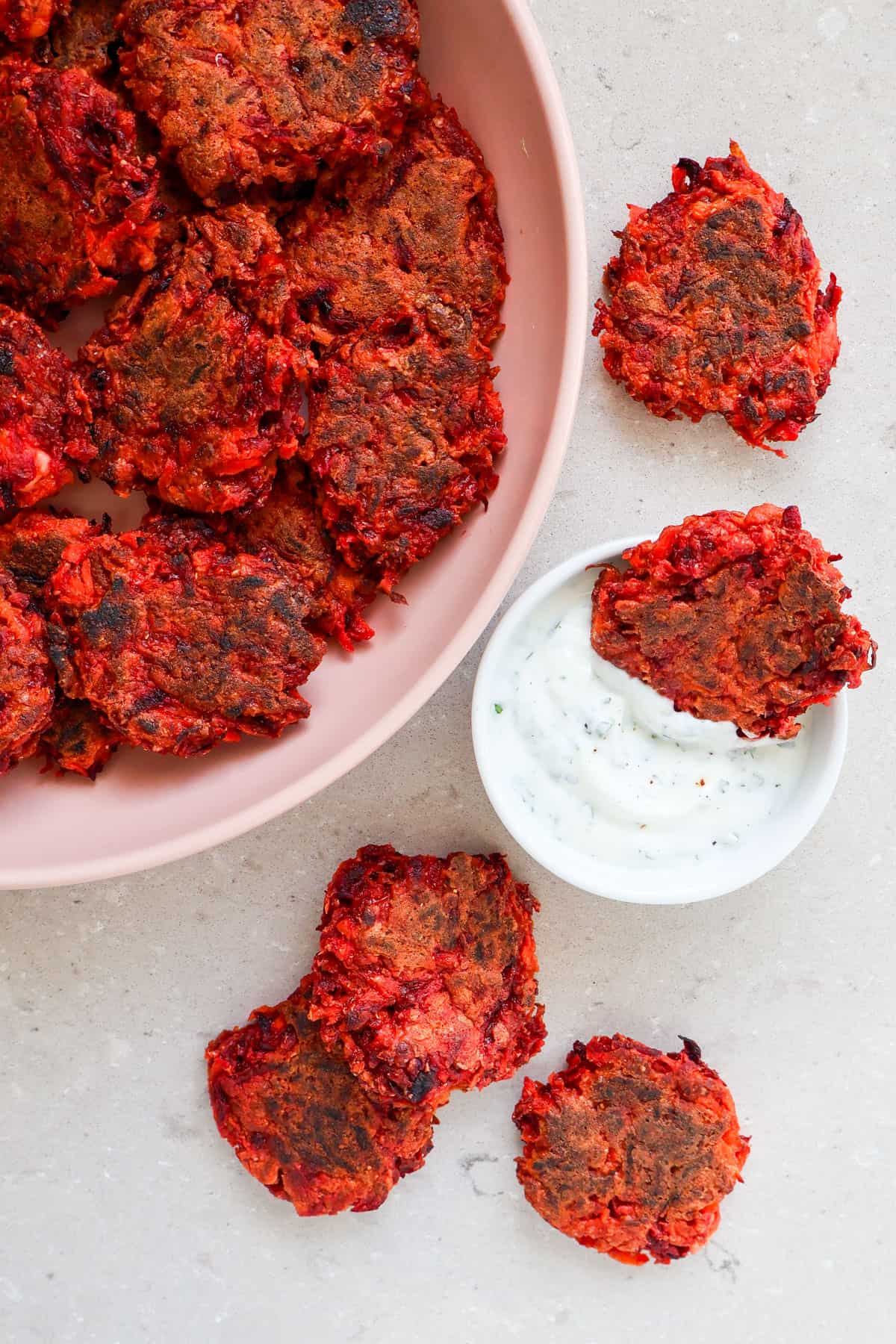 Fritters on a plate with yoghurt sauce.