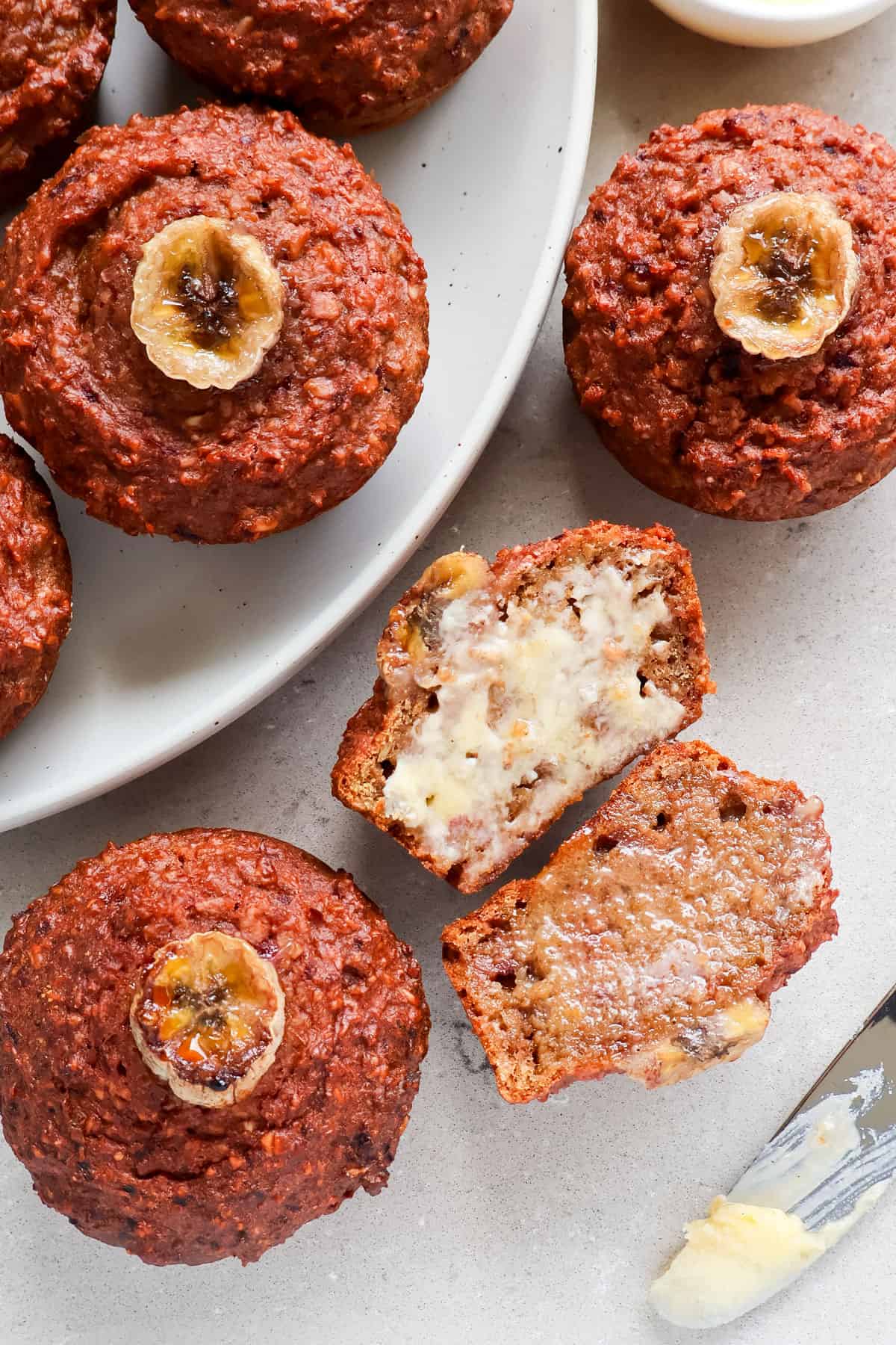 Close up shot of a muffin cut in half spread with butter.