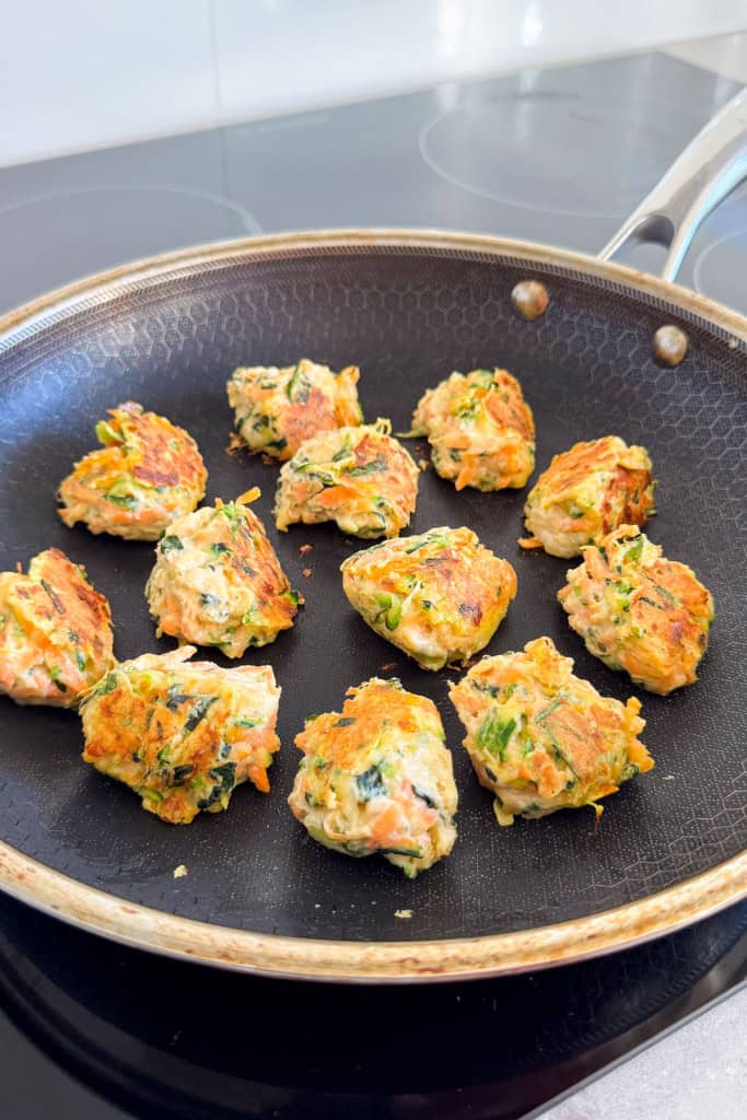 Fritters cooking in a pan.