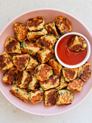 Ricotta veggie fritters in a bowl with ketchup.