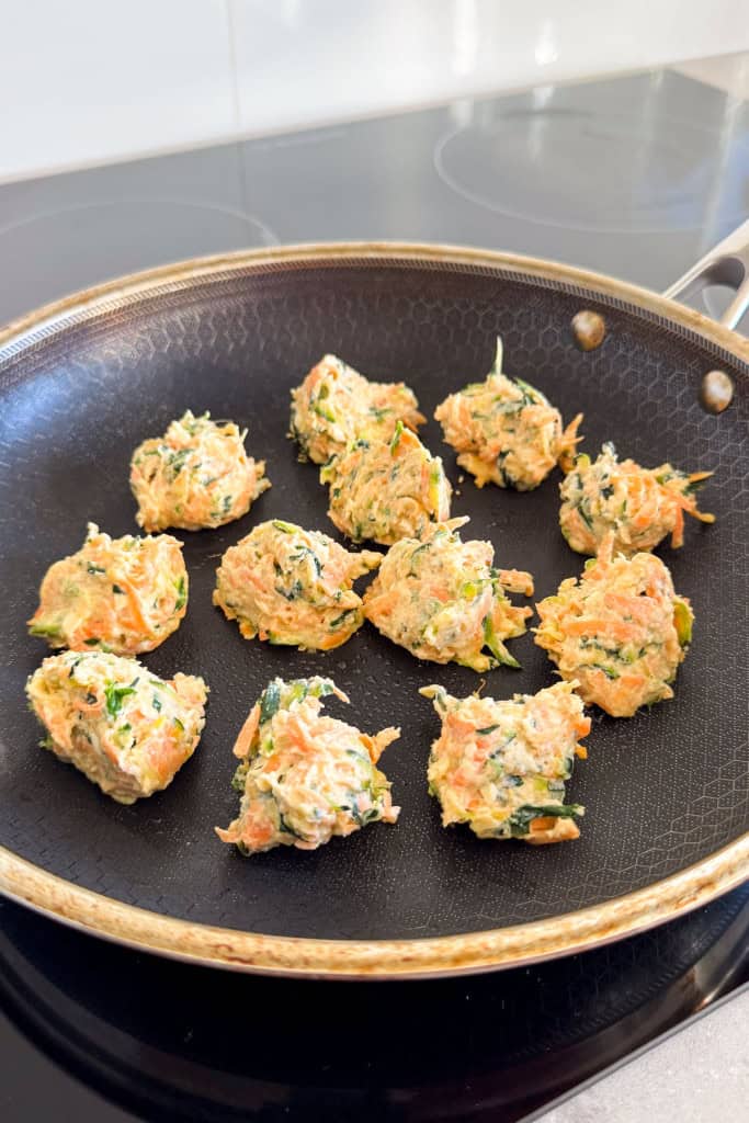 Fritters cooking in a pan.