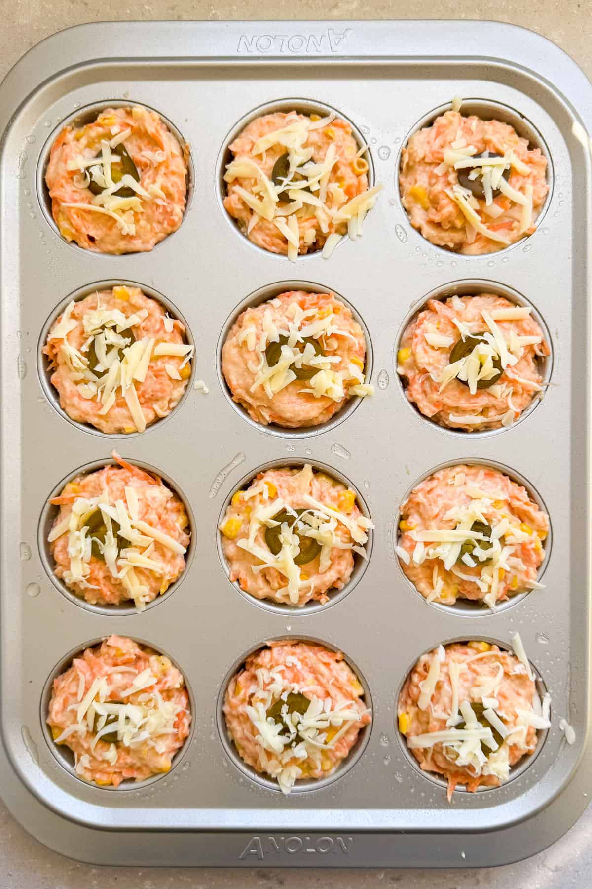 Batter added to a muffin pan.