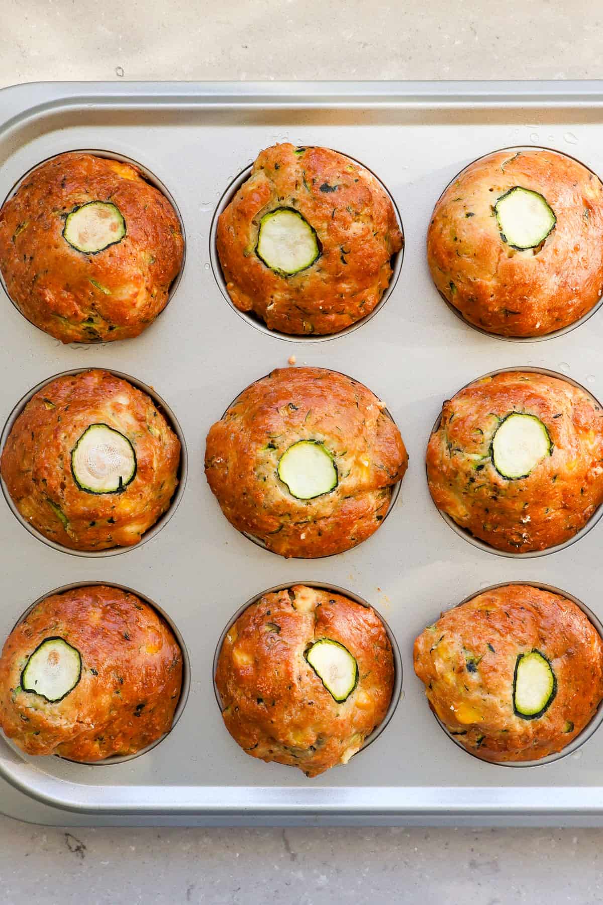 Zucchini Feta muffins in pans.