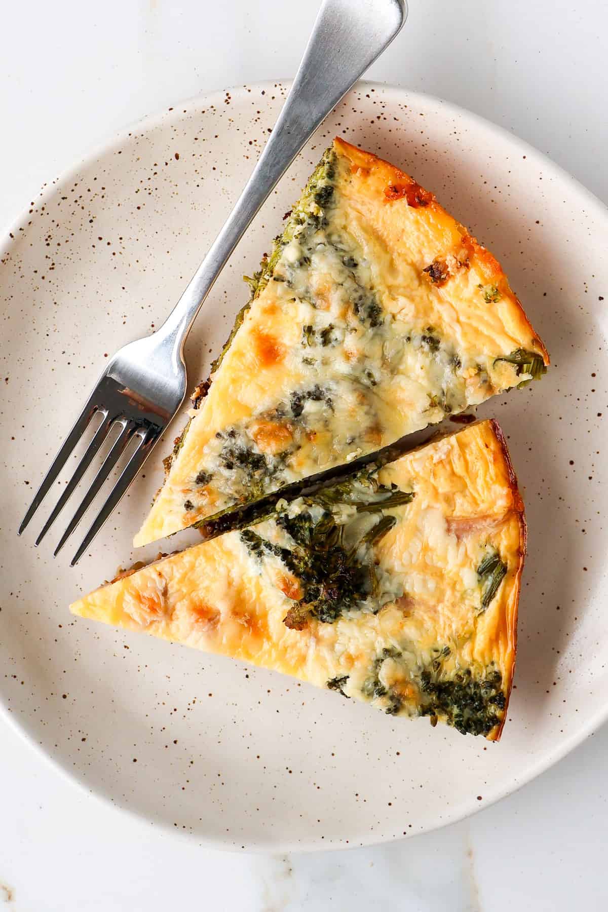 Two slices of broccolini frittata on a plate.
