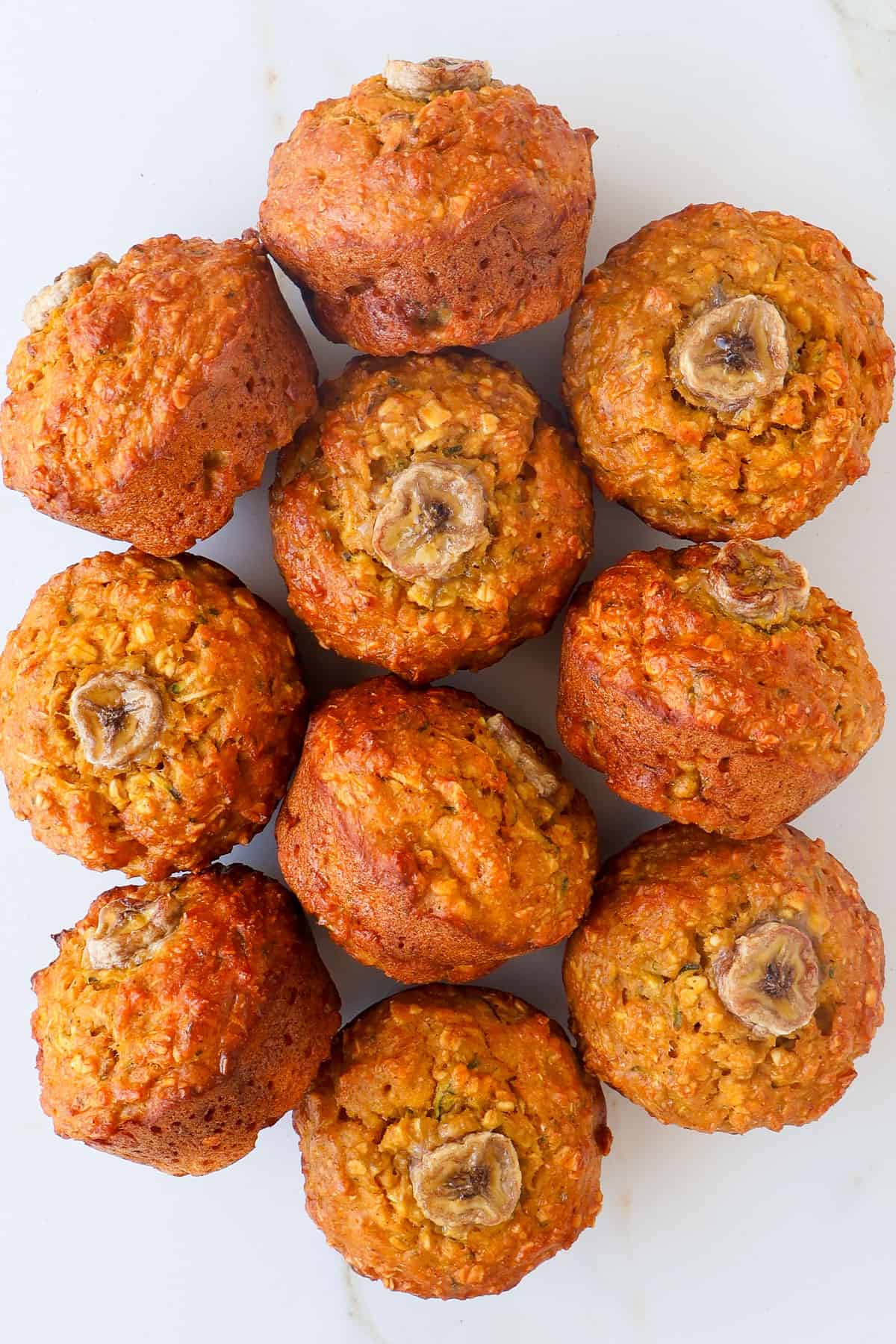 Pumpkin muffins on a plate on a table top and side view.