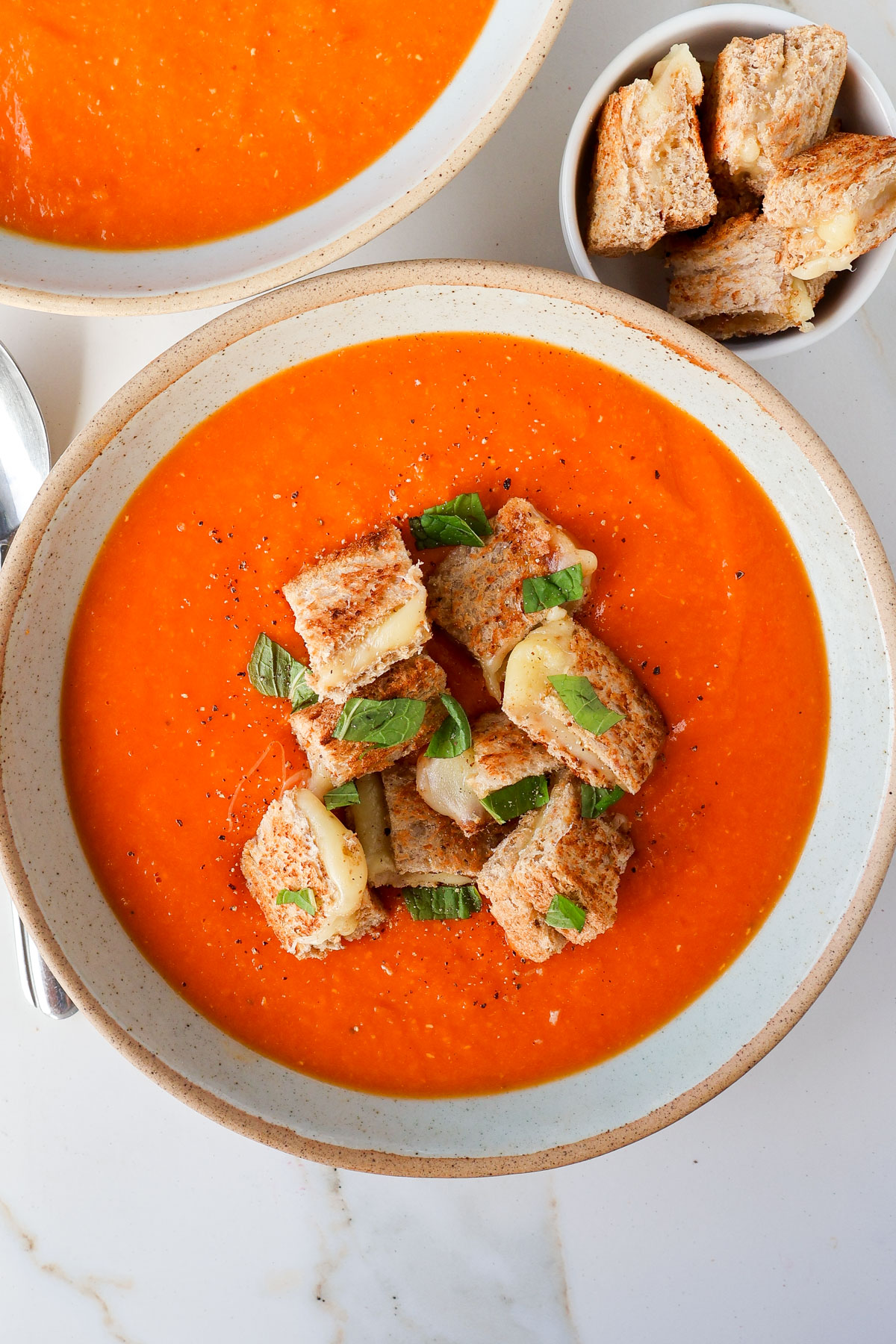 Soup in bowls with grilled cheese croutons.