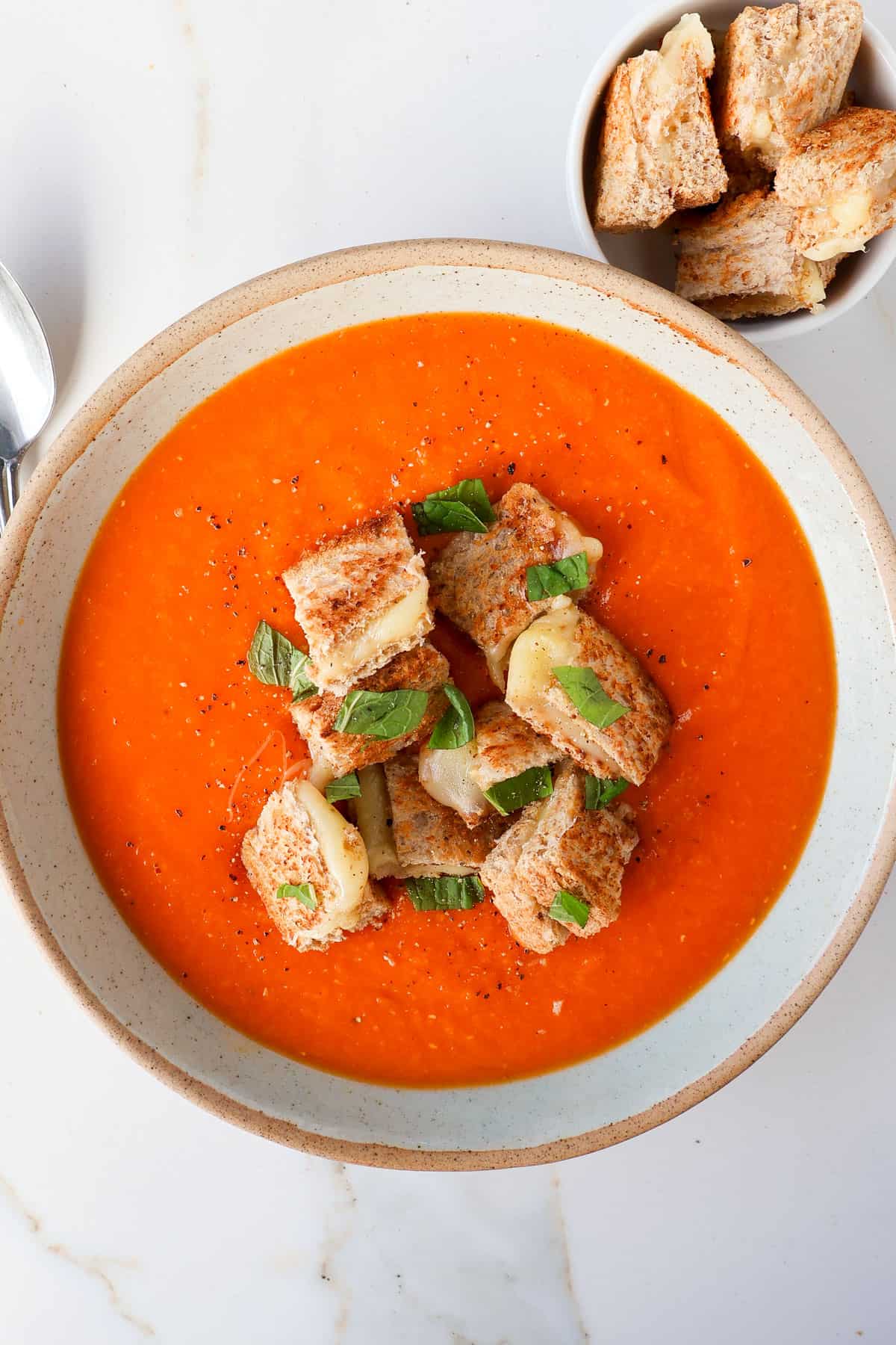 Soup in a bowl with grilled cheese croutons.