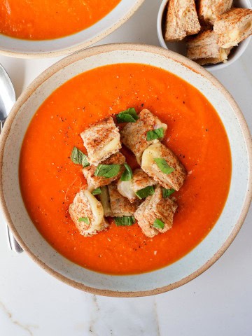 Soup in bowls with grilled cheese croutons.