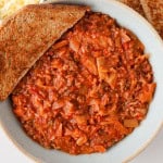 Ground beef casserole in a bowl with bread on the side.