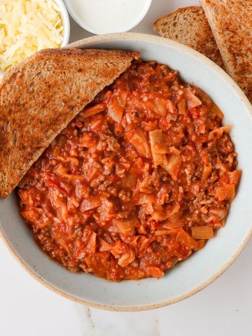 Ground beef casserole in a bowl with bread on the side.