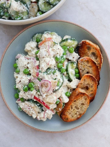Chicken salad served on a plate with toasts.