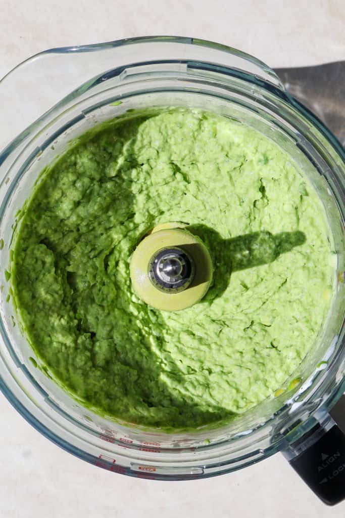 Blended pea dip in a food processor jug.