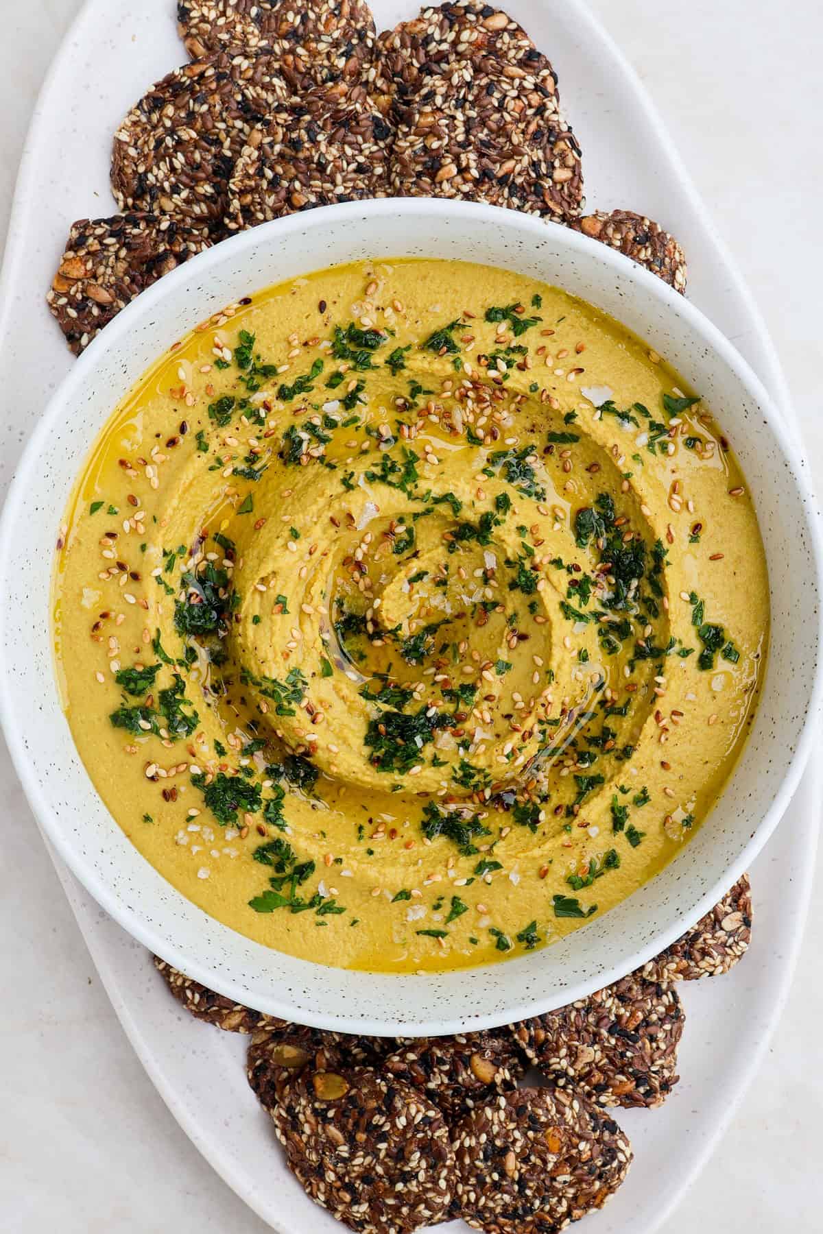 Hummus in a bowl on a cracker platter.