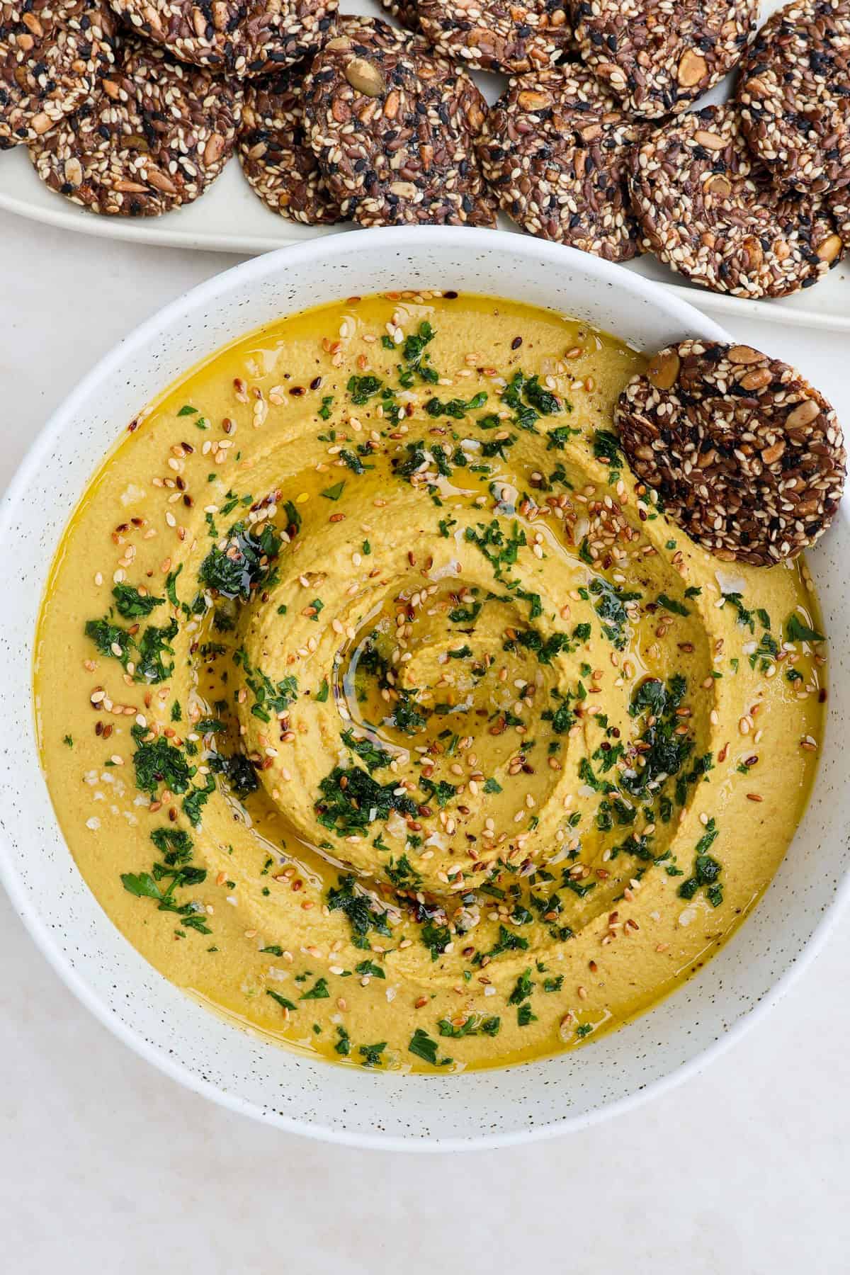 Hummus with a cracker dipped in on the side.